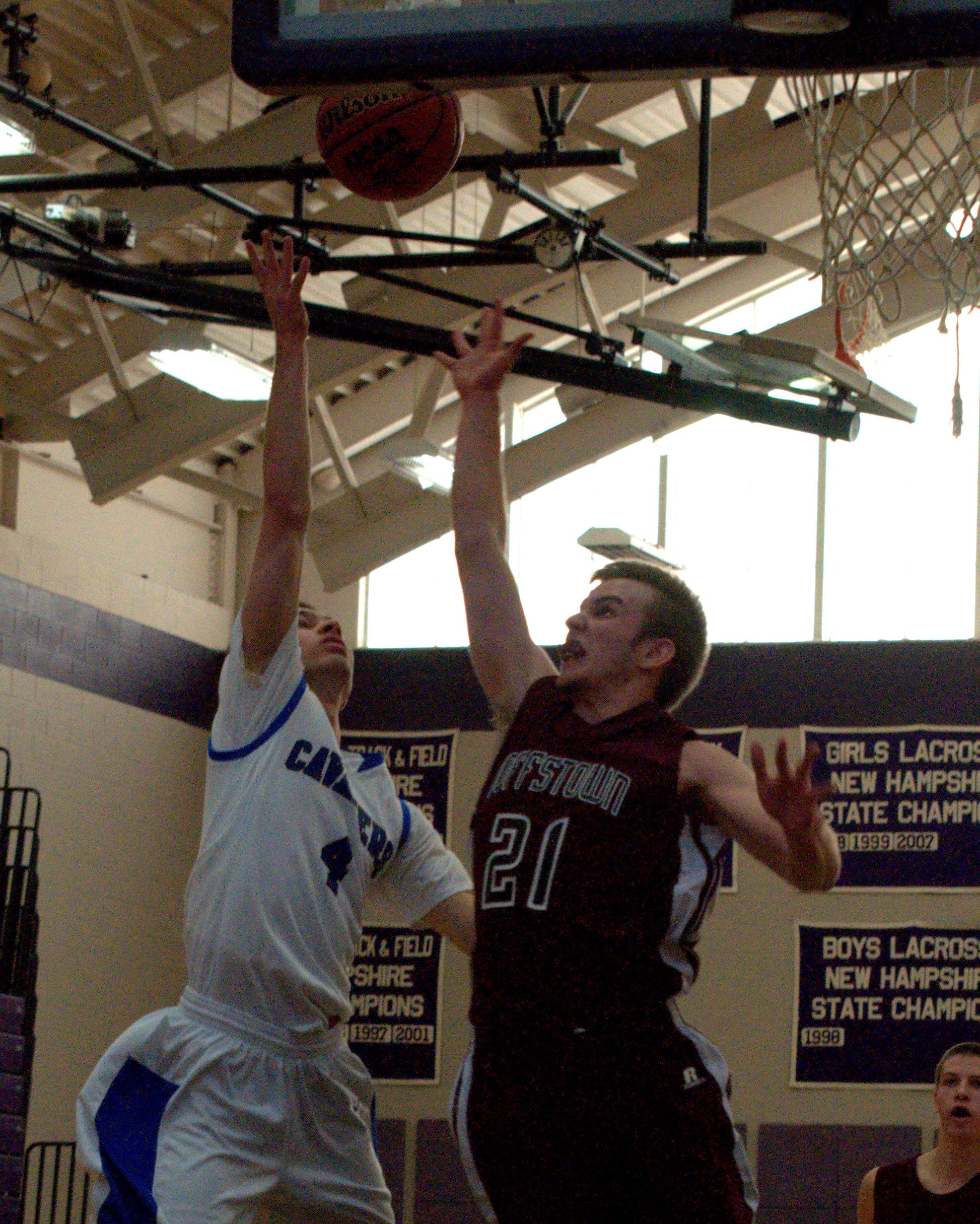 Goffstown's Mike Bailey tries to get a piece of a shot by Hollis Brookline's Matt Fothergill.