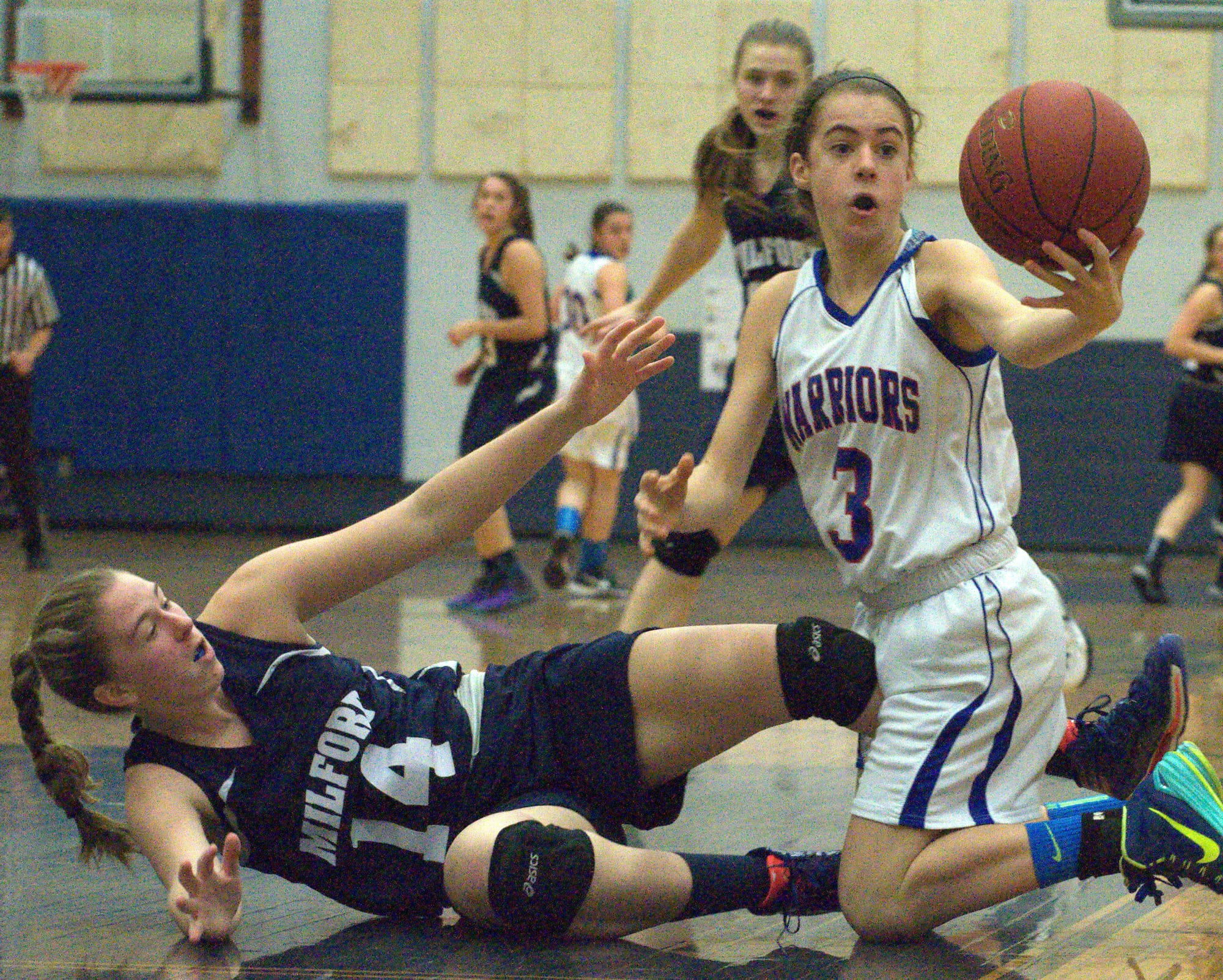 Winnacunnet's Kelly Aresenault tries to hang on to the ball after knocking it away from Milford's Jessica Ryan during Sunday's championship game.