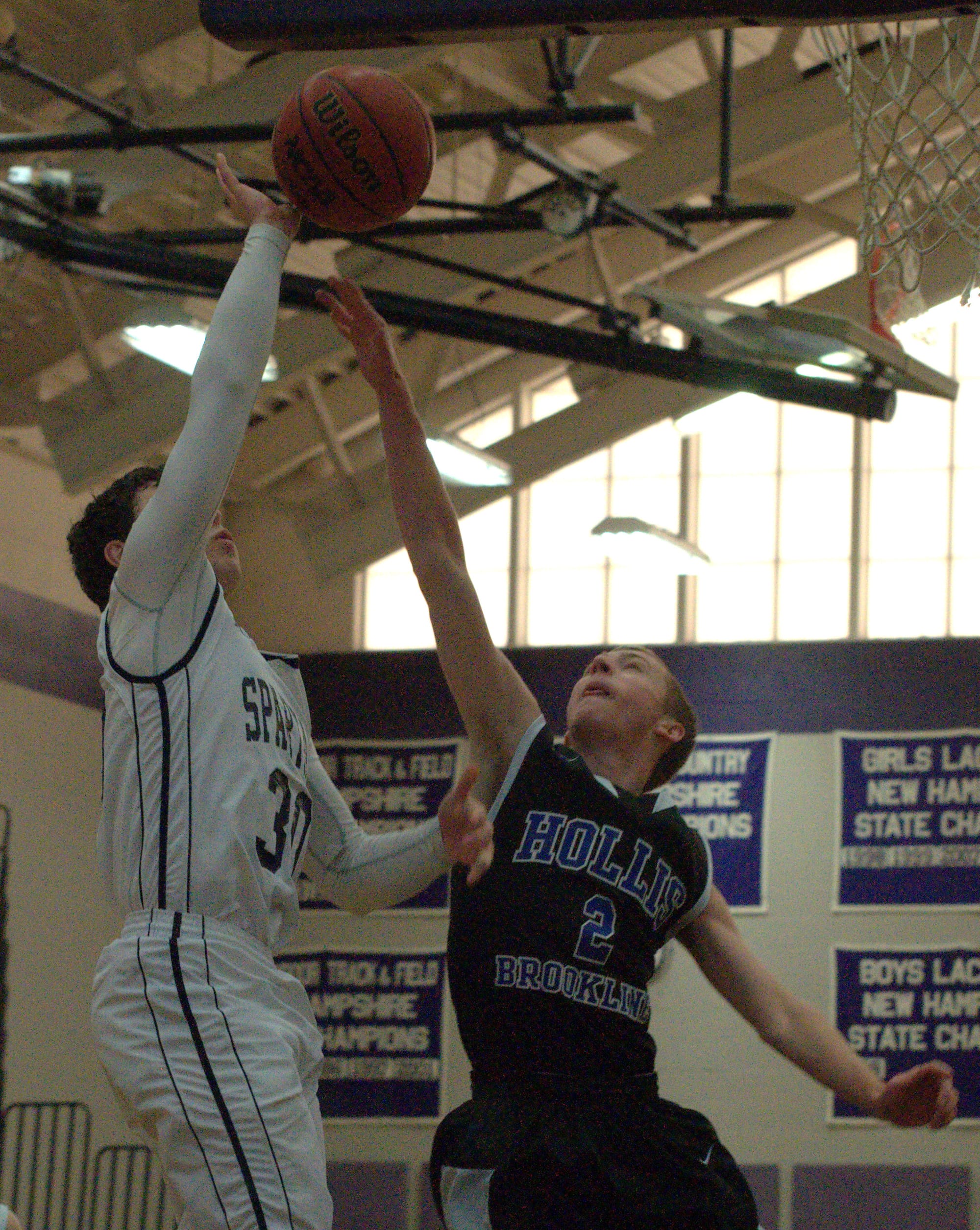 Milford's Drew Lesmerises puts up a shot just out of the reach of Hollis Brookline's Nick Fothergill during Tuesday's game.
