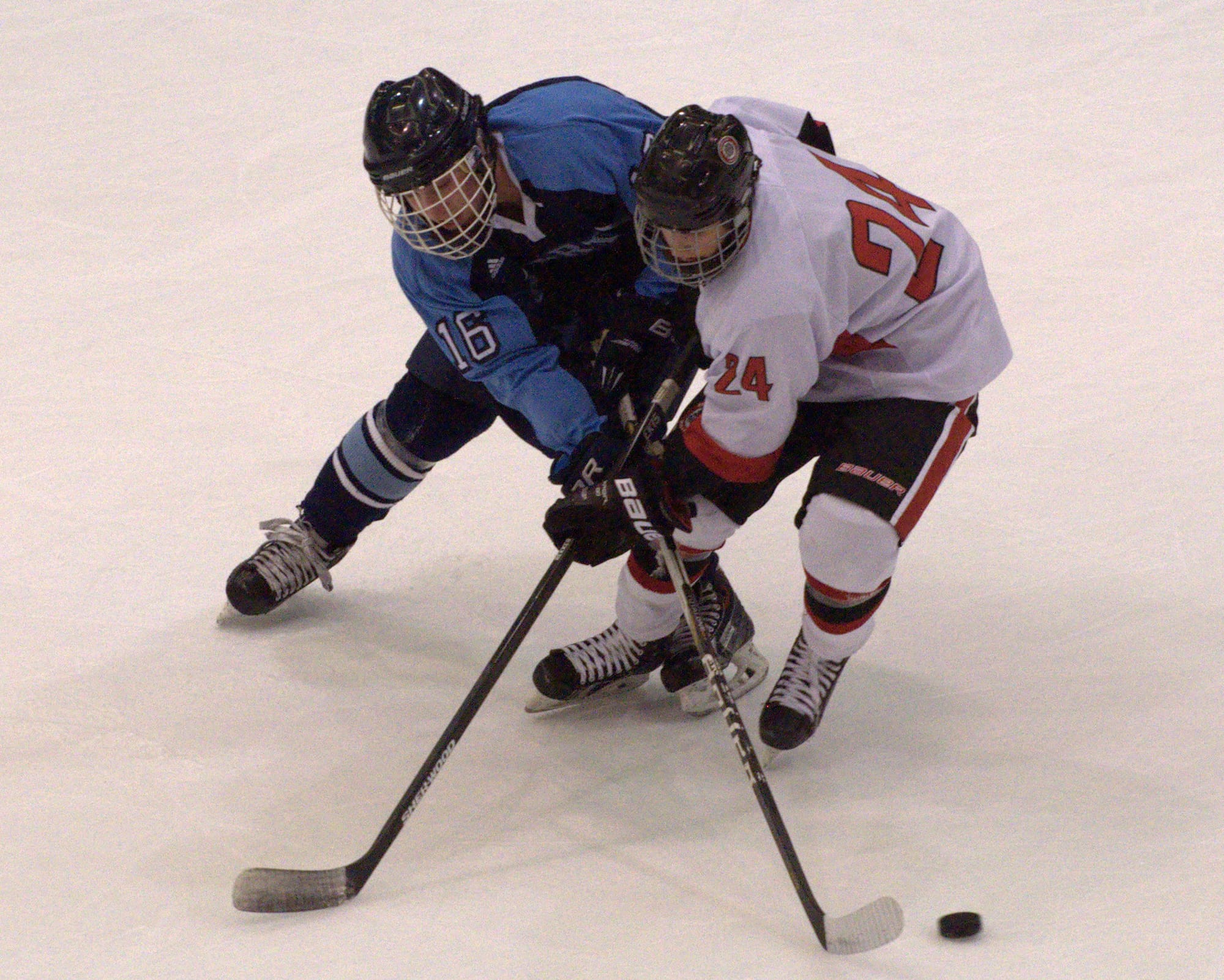 Nashua North's Robert LaVine knocks the puck away from Bedford's Jacob Rioux during Wednesday's game.