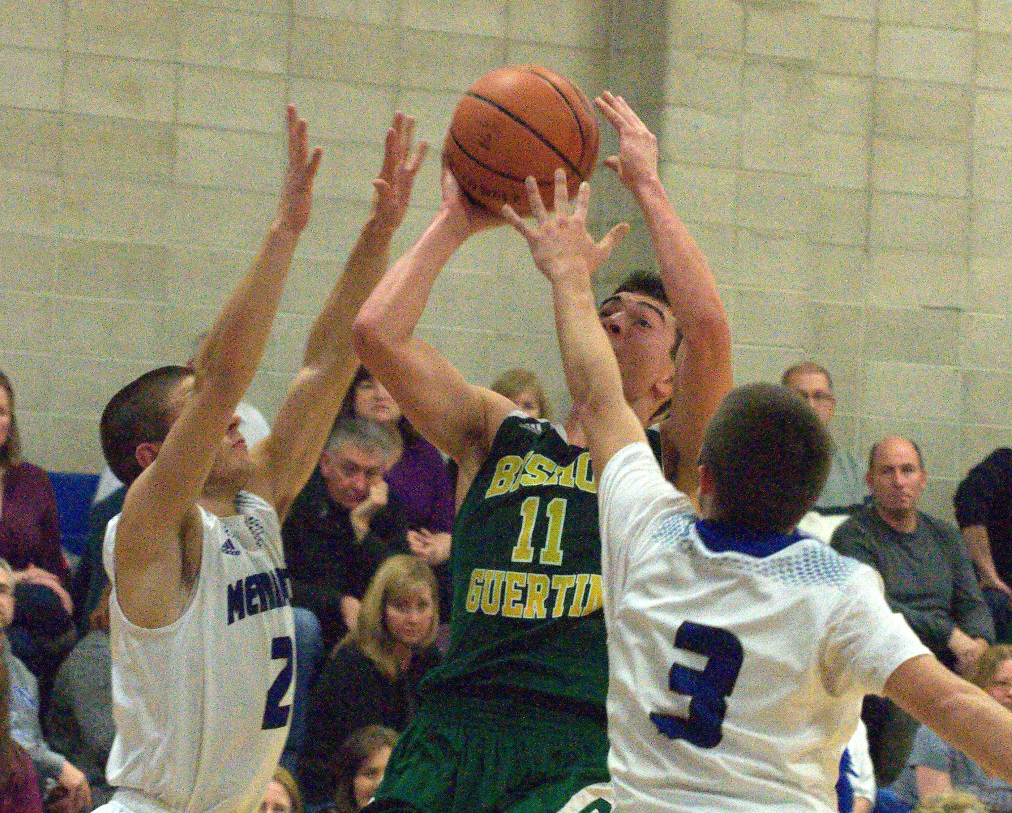 Bishop Guertin's Jack Zimmerman tries to take a shot as Merrimack's Chad Seaver and Austin Franzen defend during Friday's game.