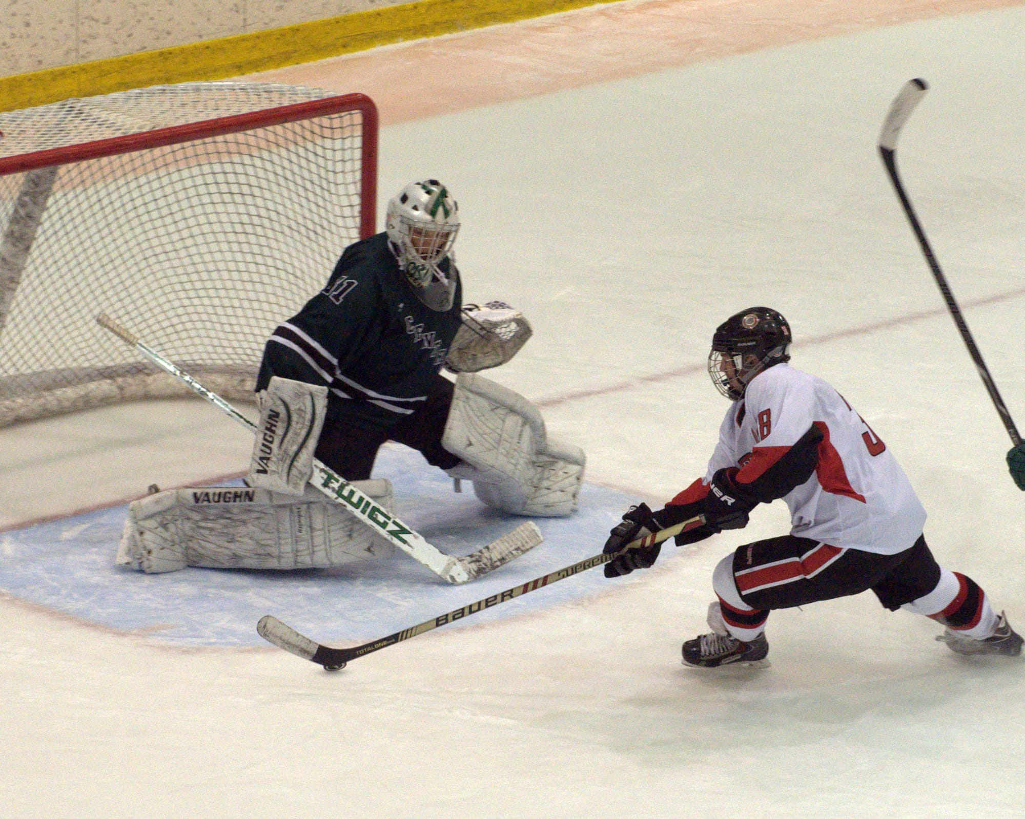 Bedford's Brett Veilleux moves in on Manchester Central goalie Mathieu Cislak during Saturday's game.