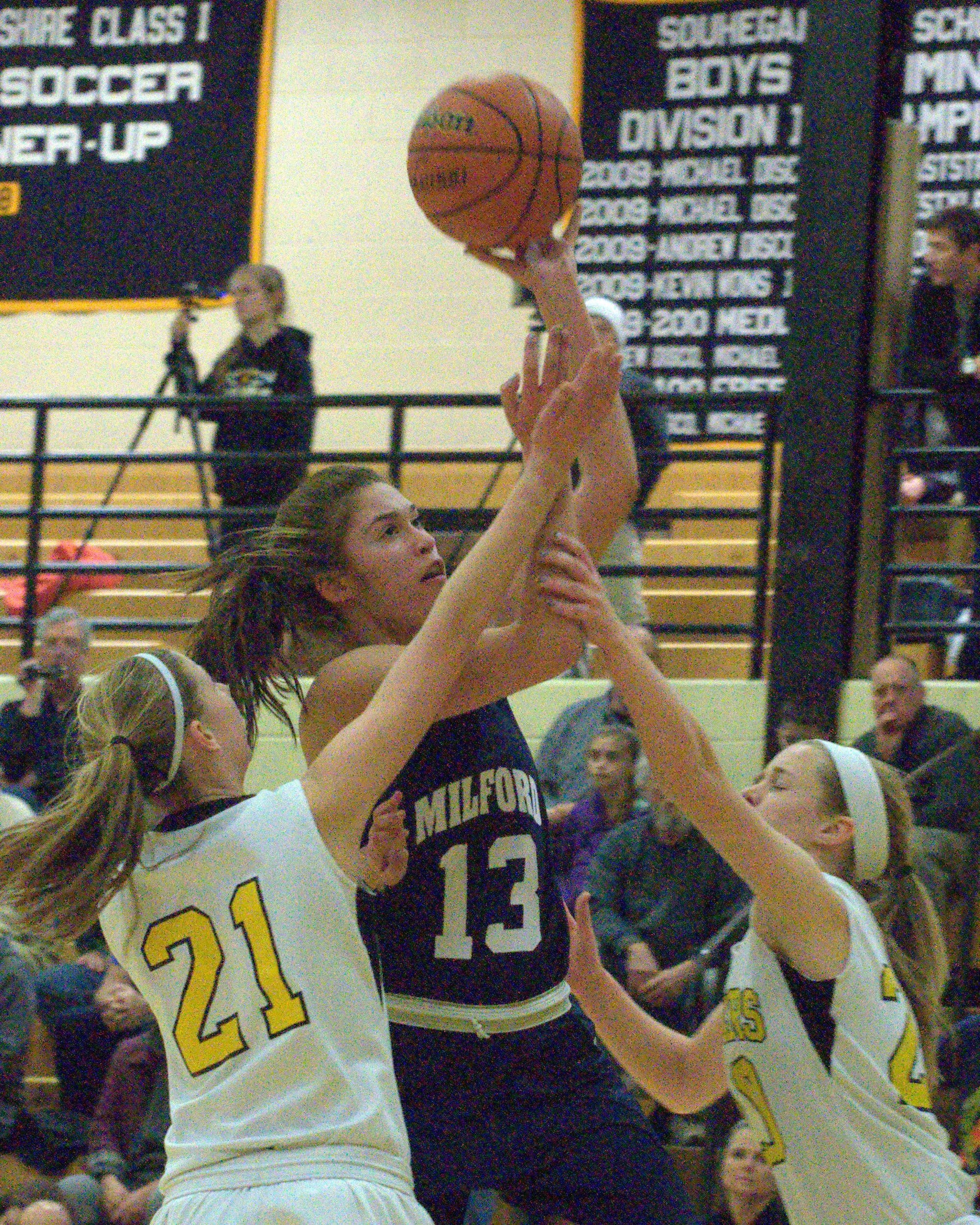 Milford's Becca Cleary drives to the basket between Souhegan's Emma White, left, and Caitlin Watson during Tuesday's game.
