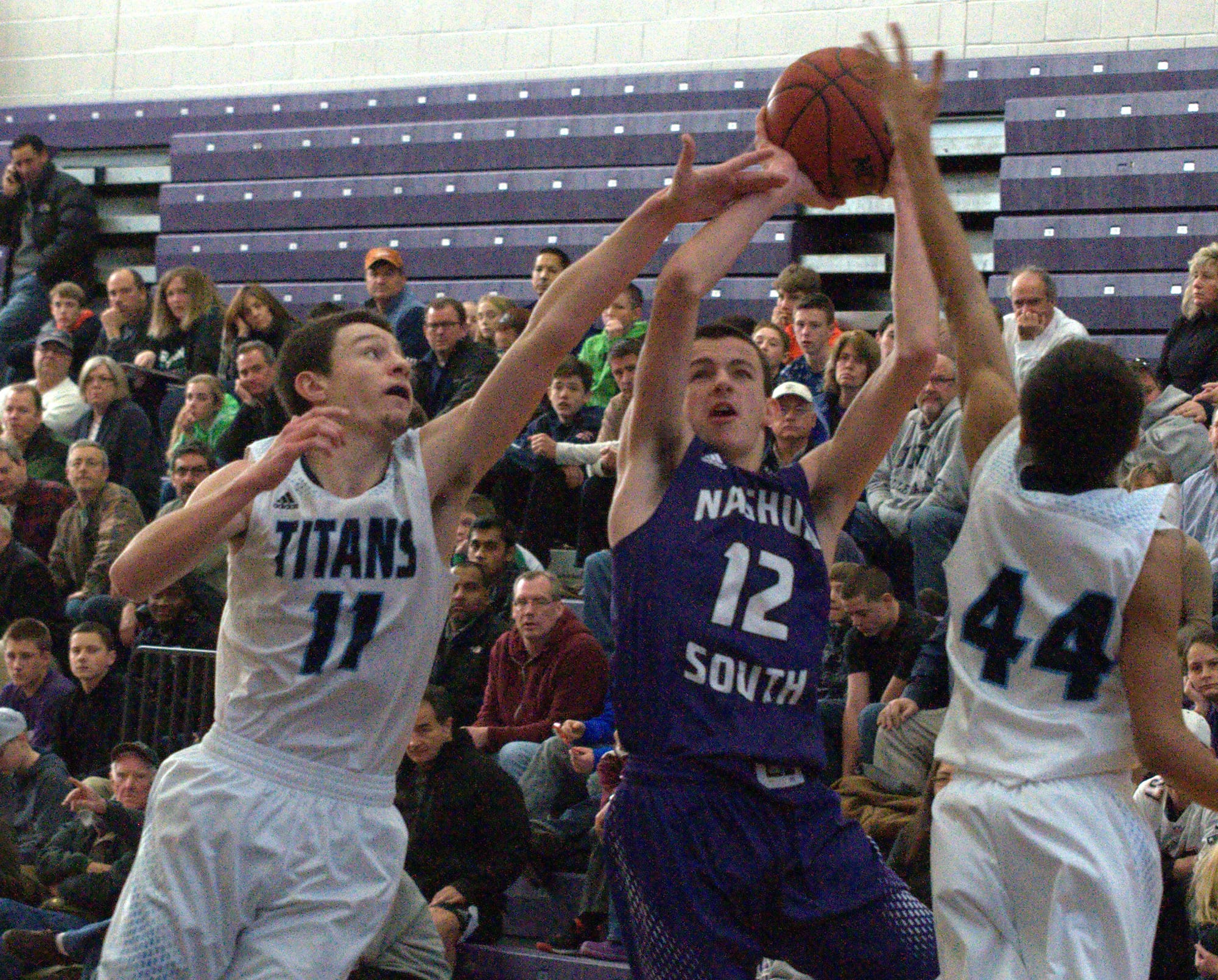 Nashua South's DJ Frechette tries to get to the basket between Nashua North's Brendan Barrett, left, and Ronnie Silva.