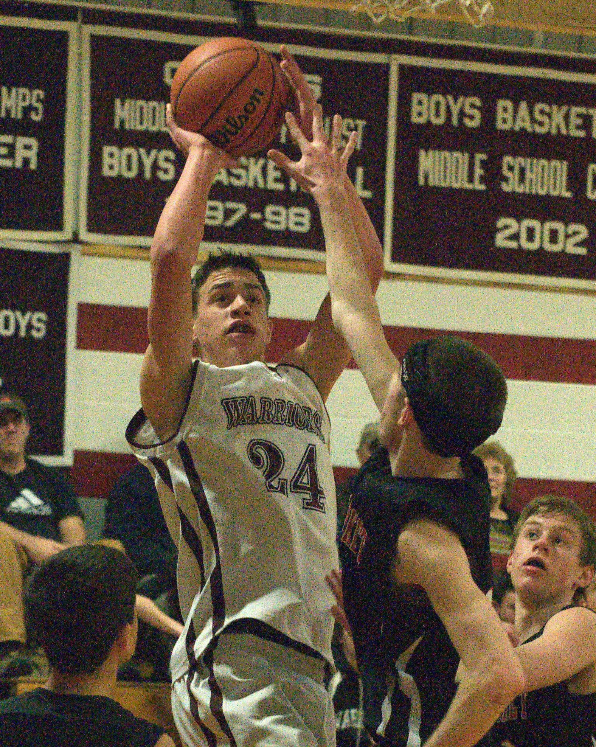 Wilton-Lyndeborough's Trey Carrier puts up a shot over Newmarket's Ian Bentley during Tuesday's game.