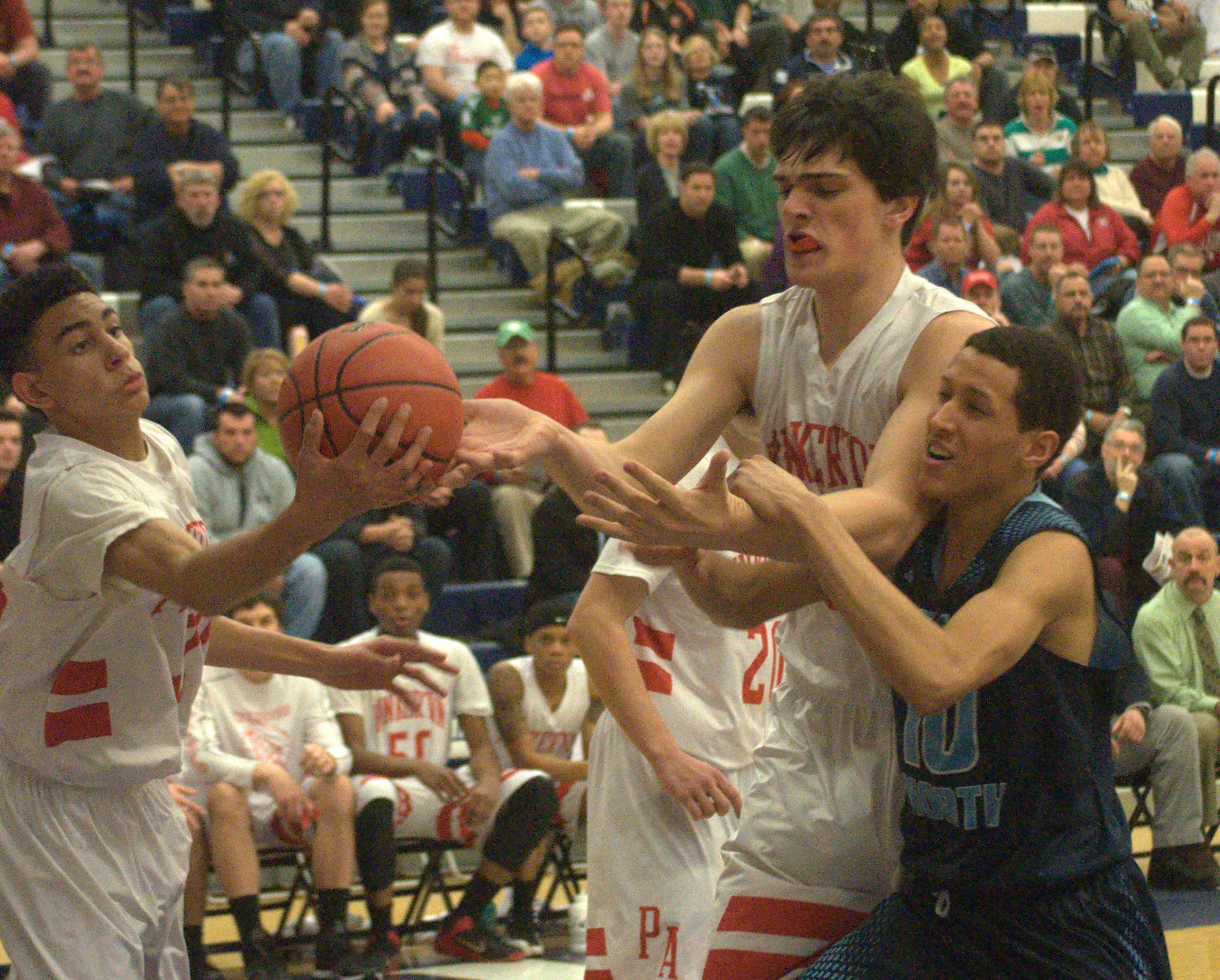 Pinkerton's Geo Baker, left, and Benjamin Olsen battle with Nashua North's Jefry Almonte for a rebound during Tuesday's game.