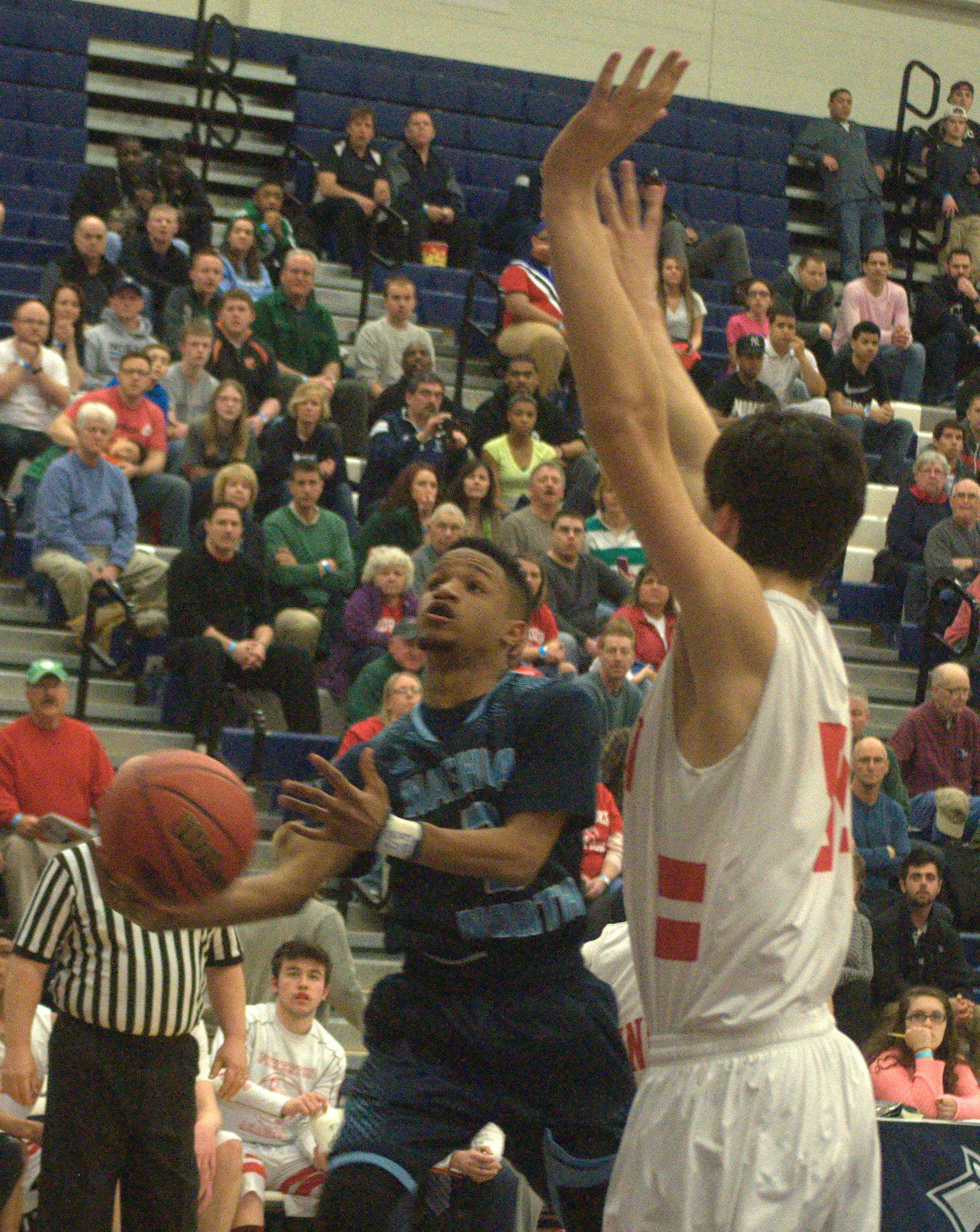 Pinkerton's Thomas Olson tries to defend Nashua North's Alejandro John as he goes in for a basket.
