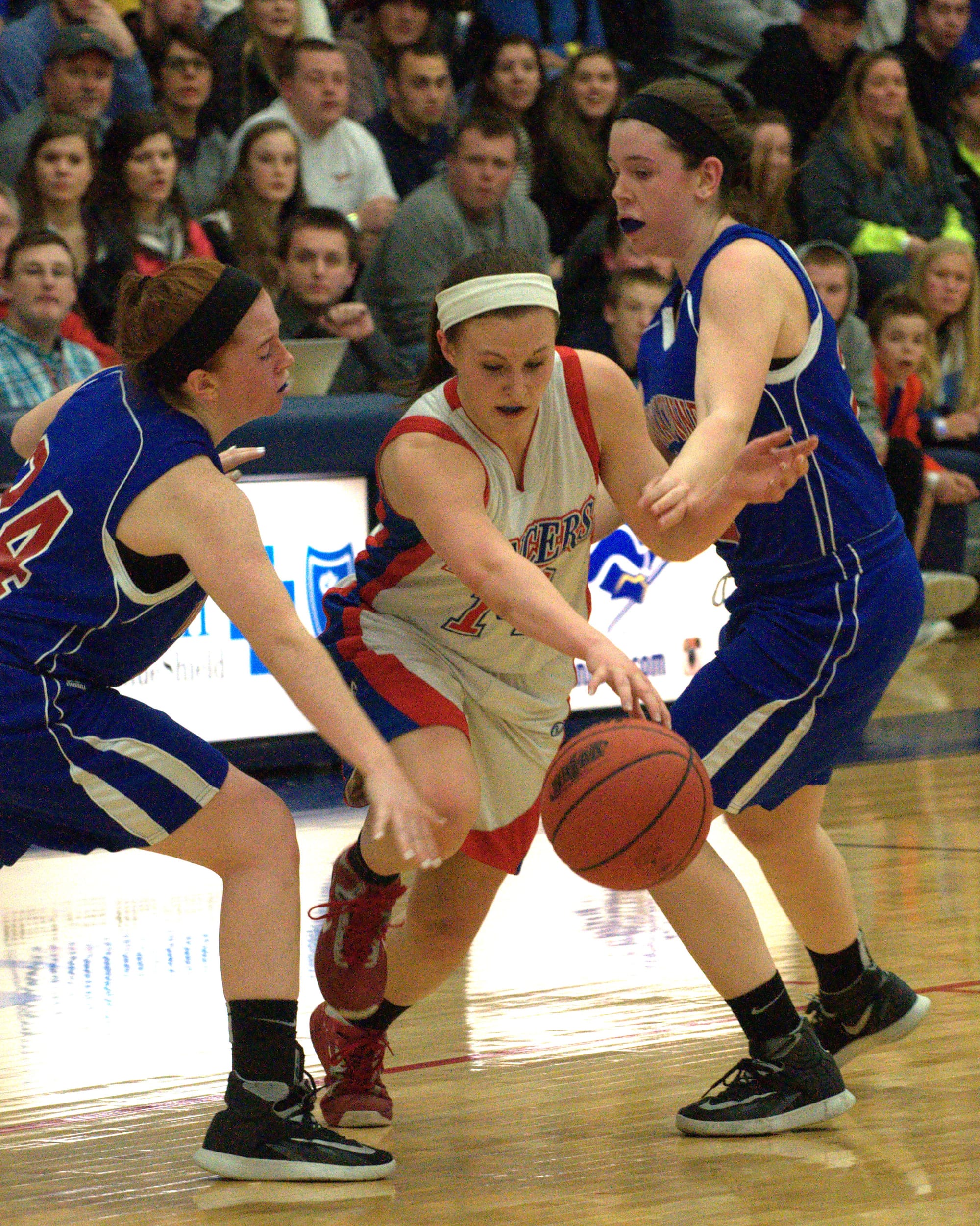 Londonderry's Jaclyn Luckhardt dribbles between Winnacunnet's Molly Britton, left, and Emily Britton.