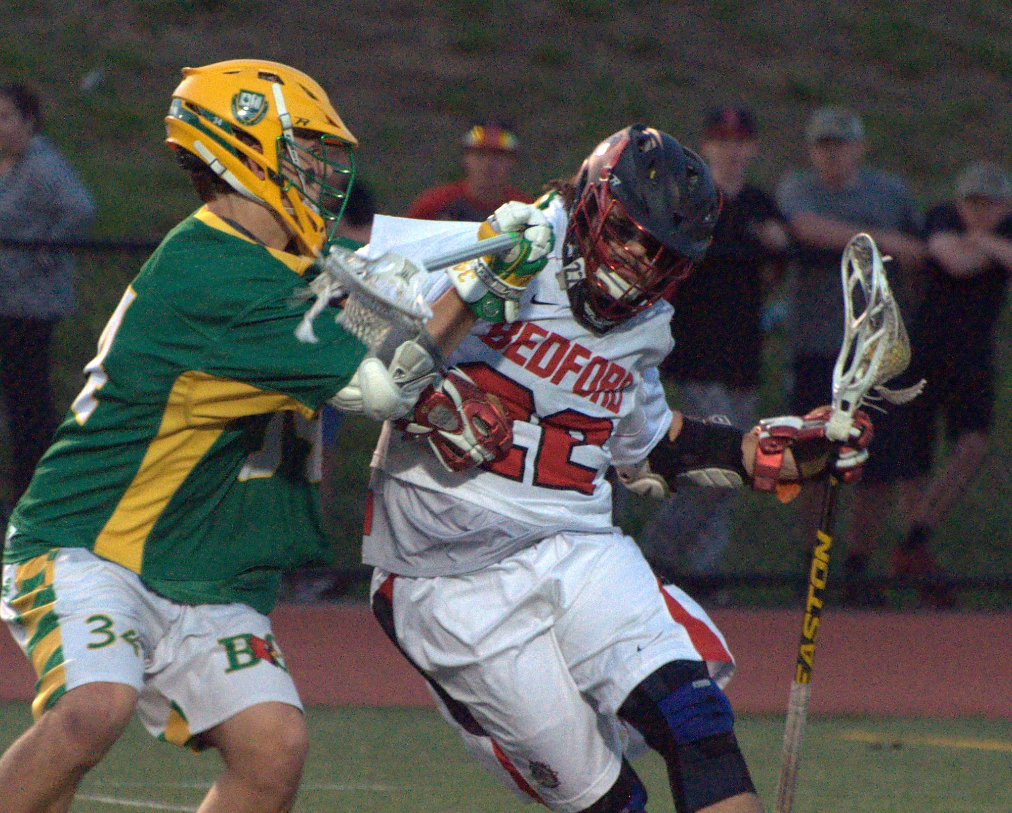 Bedford's Colin Hendrickson tries to fight off a hit by Bishop Guertin's William Lewis during Thursday's game.