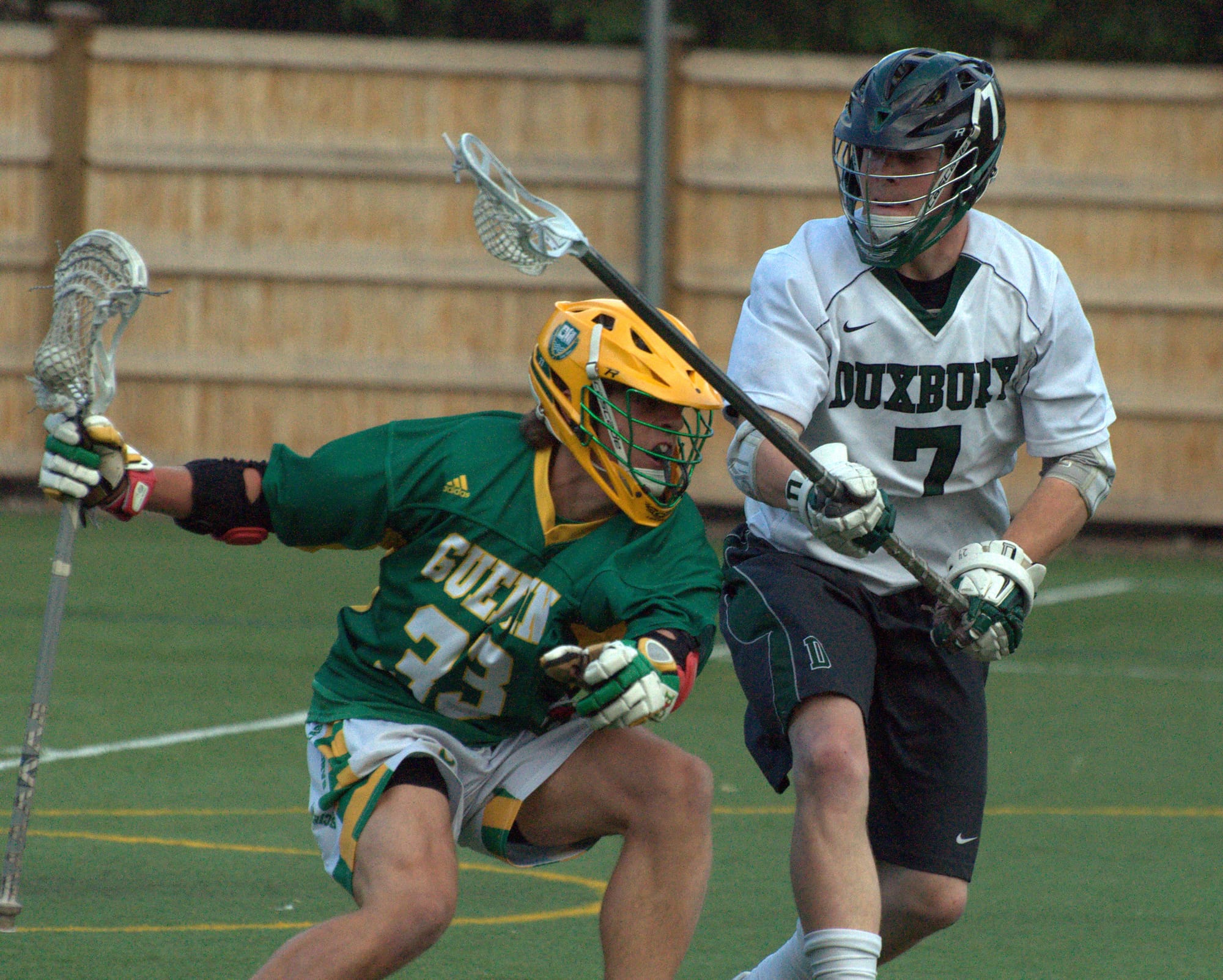 Bishop Guertin's Alex Astarita tries to duck around the stick of Duxbury's Hunter Marston during Wednesday's game.