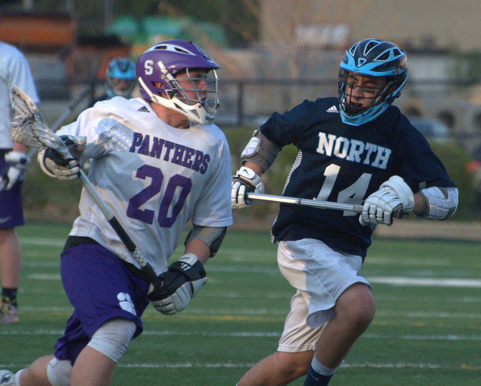 Nashua North's Tyler DuBien runs down field with Nashua South's Andrew DeCarteret during Friday's game.