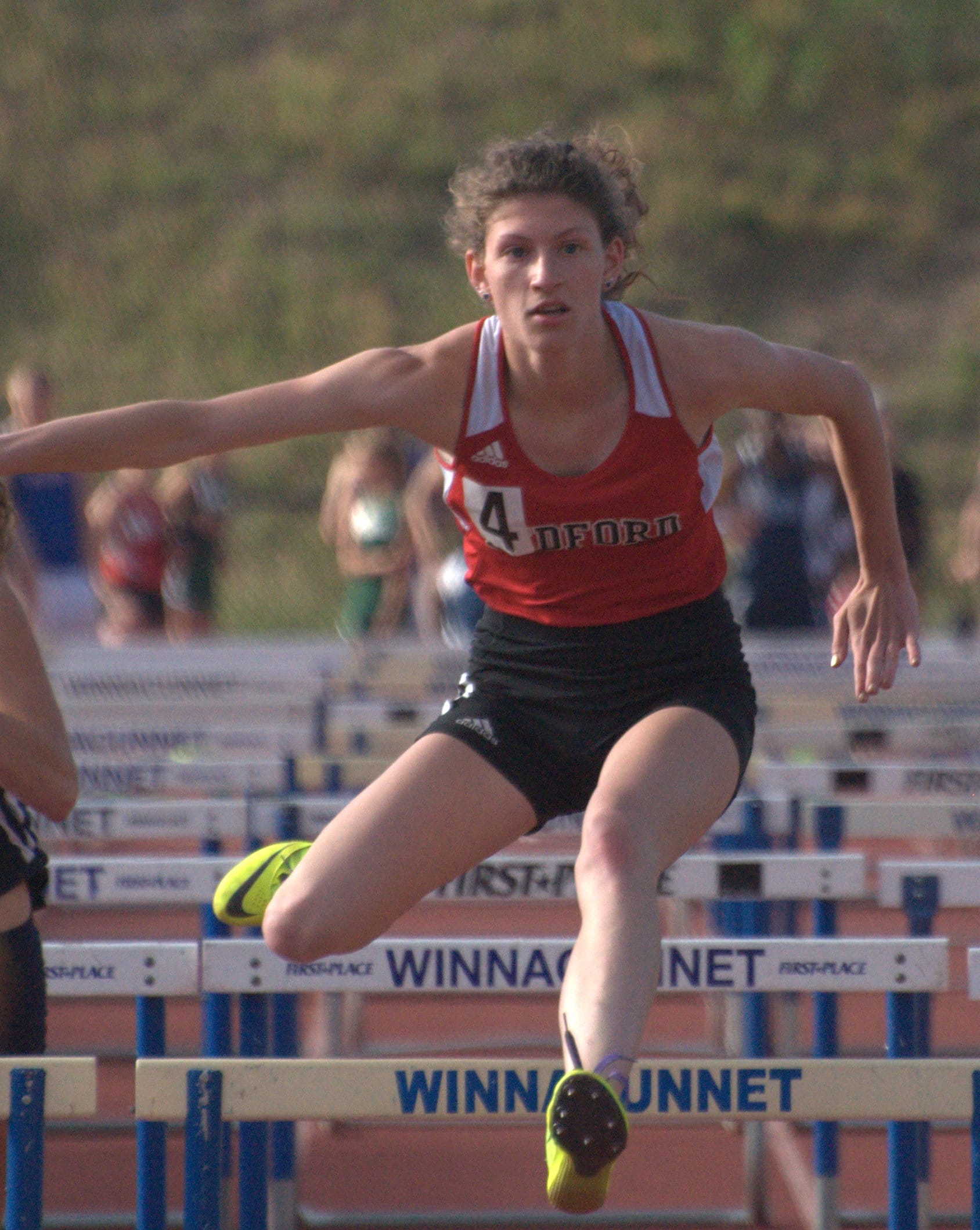Bedford's Letti Hibbard clears the final hurdle in the 100-meter hurdles.