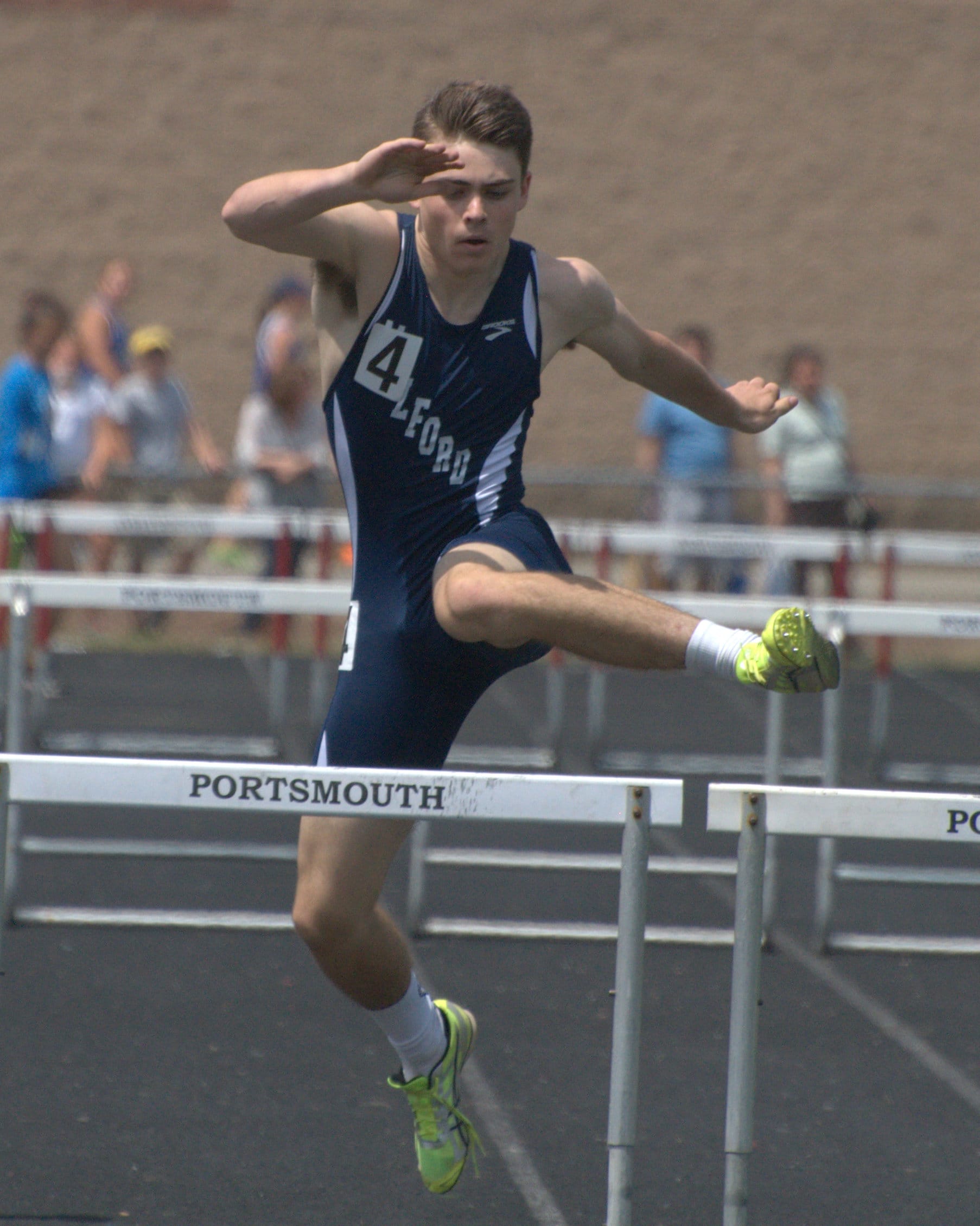 Milford's Max Urda clears a hurdle during the 300-meter hurdles.