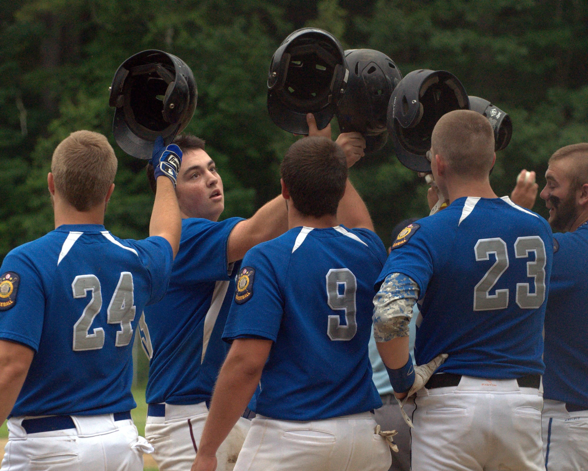 Goffstown players welcome home Kyle Perron after his first-inning grand slam Tuesday against Milford.