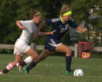 Hollis Brookline's Sydney Brackett tries to get by Milford's Geena Ciardelli.