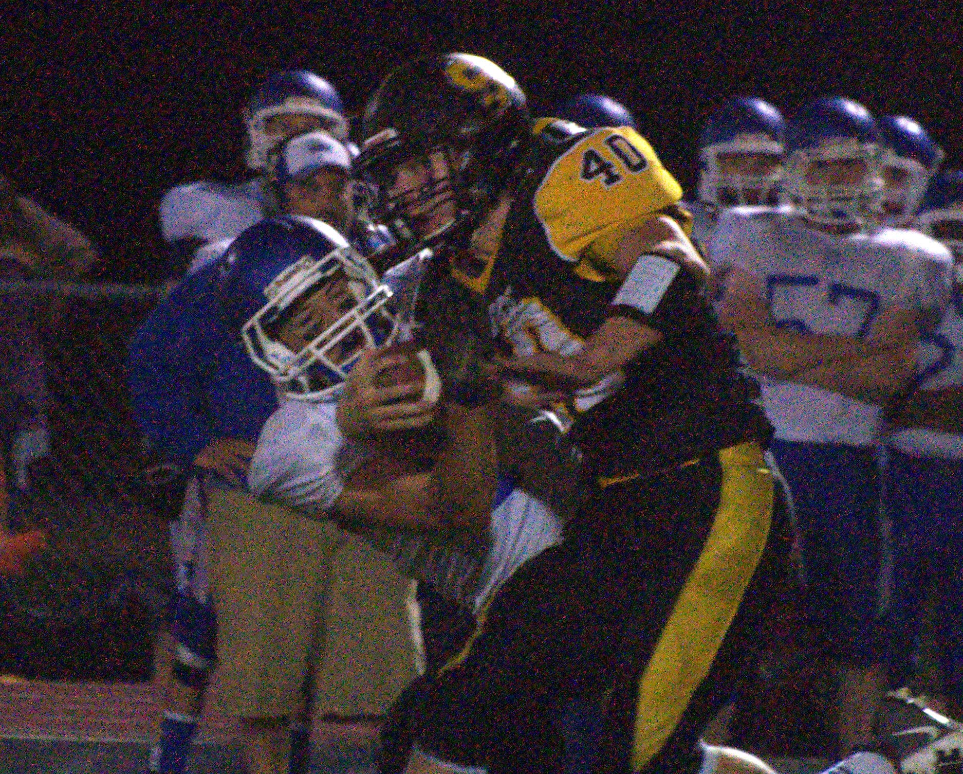 Souhegan's Cam Kinney tries to fight off a tackle.
