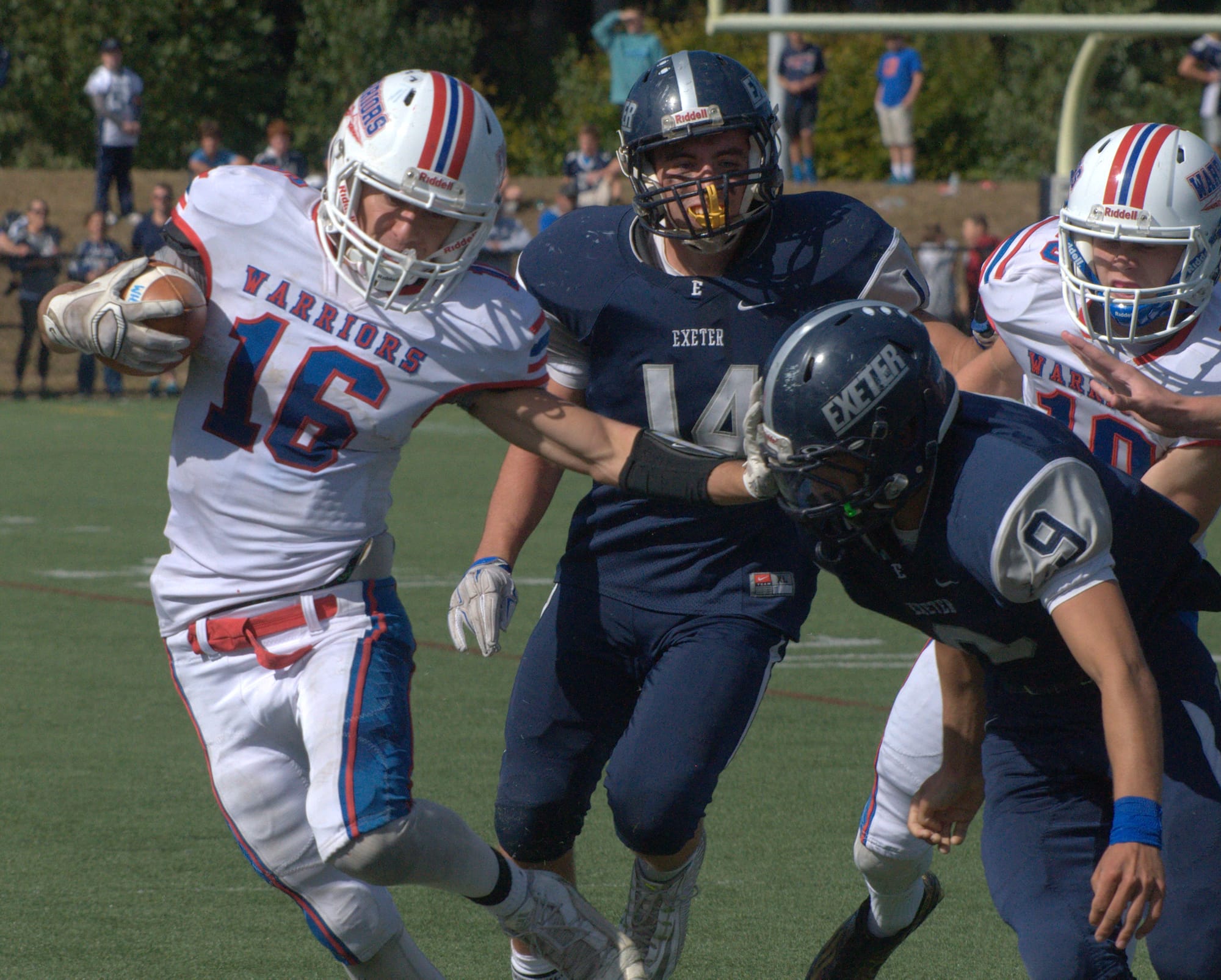 Winnacunnet's Brian Auffant stiffarms Exeter's Kyle Ball during Saturday's game.