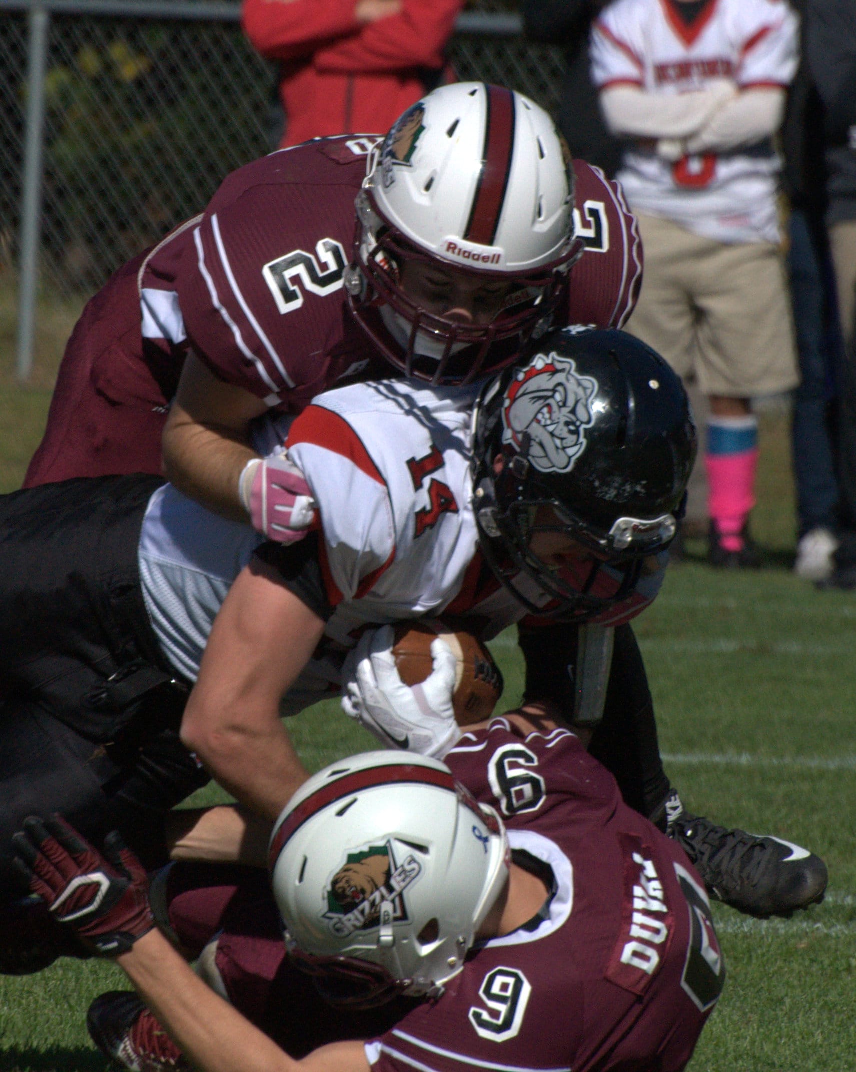 Goffstown's Cam Bond, top, and Andrew Duval team up to tackle Bedford's Nick Leahy.