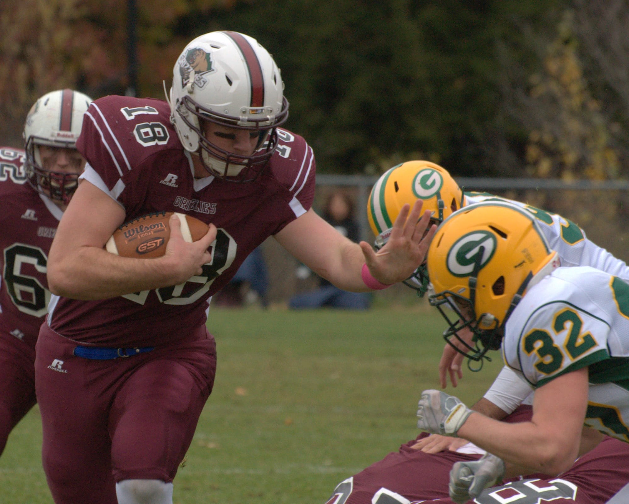 Goffstown's Casey Gervais tries to stiff arm Bishop Guertin's Keenan Dwyer during Saturday's game.