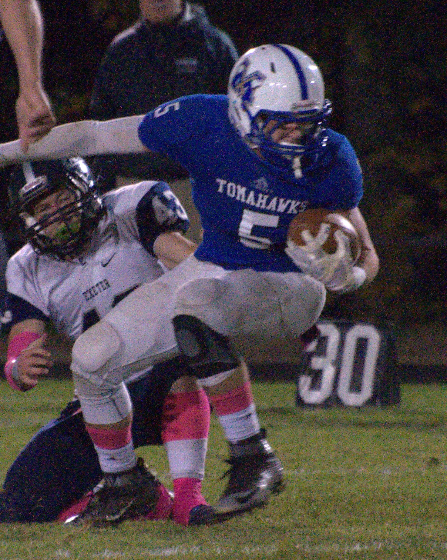 Merrimack's Tyler DeNeill tries to spin out of a tackle by Exeter's Brian Doucette.