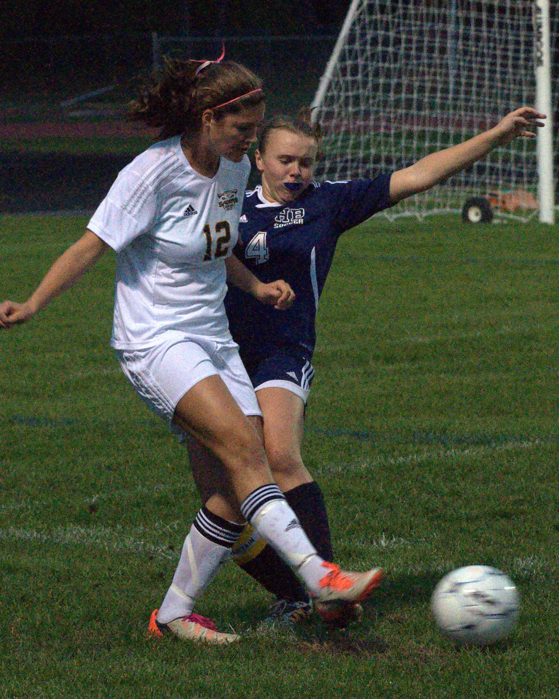 Souhegan's Emma Estabrook gets rid of the ball before Hollis Brookline's Megan Olson can get a piece of it.