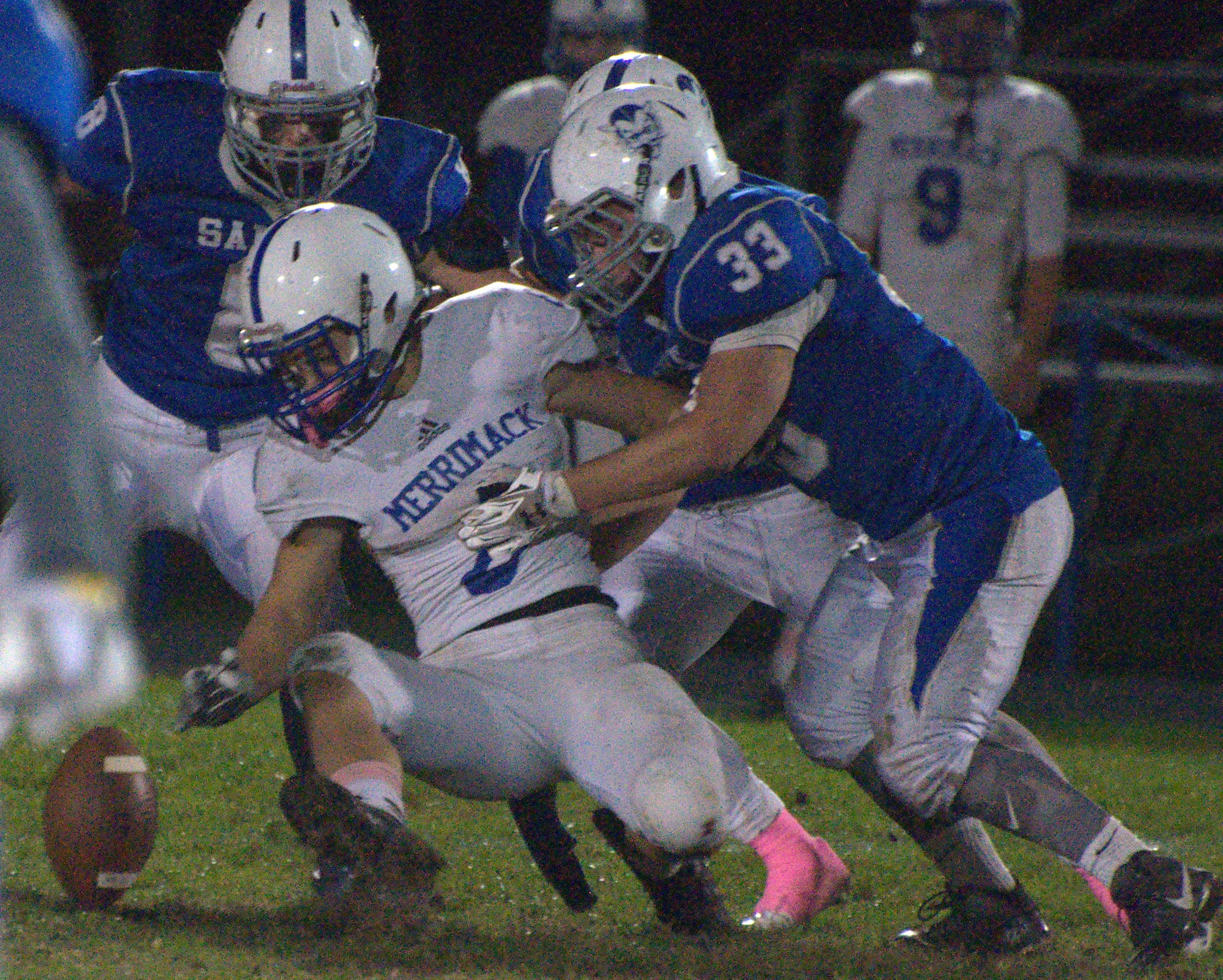 Merrimack's Joe Eichman and Salem's Doug Maroun look the football after Eichman fumbled during Friday's game.