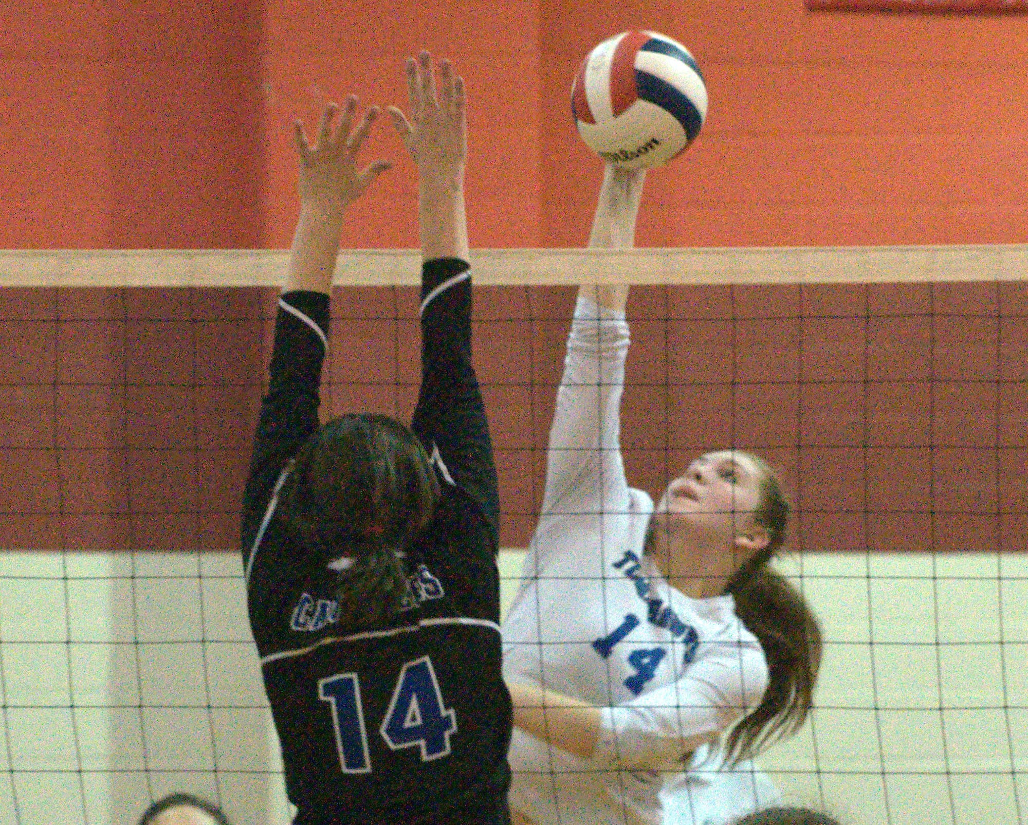 Merrimack's Katie Flynn hits the ball as Hollis Brookline's Hannah Balfour tries to get a piece of it.