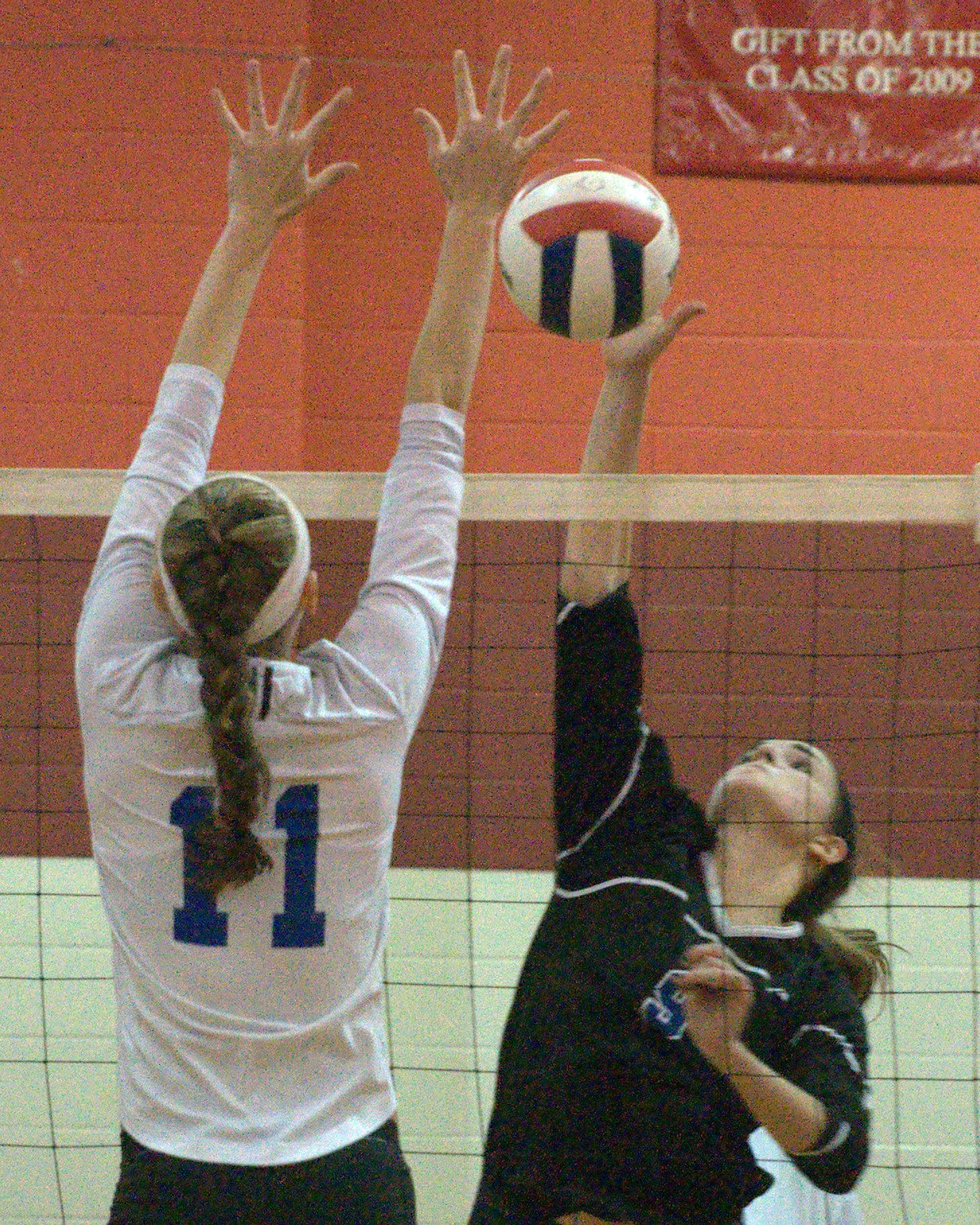 Hollis Brookline's Maddy Blake tries to hit the ball by Merrimack's Addie Lacey.