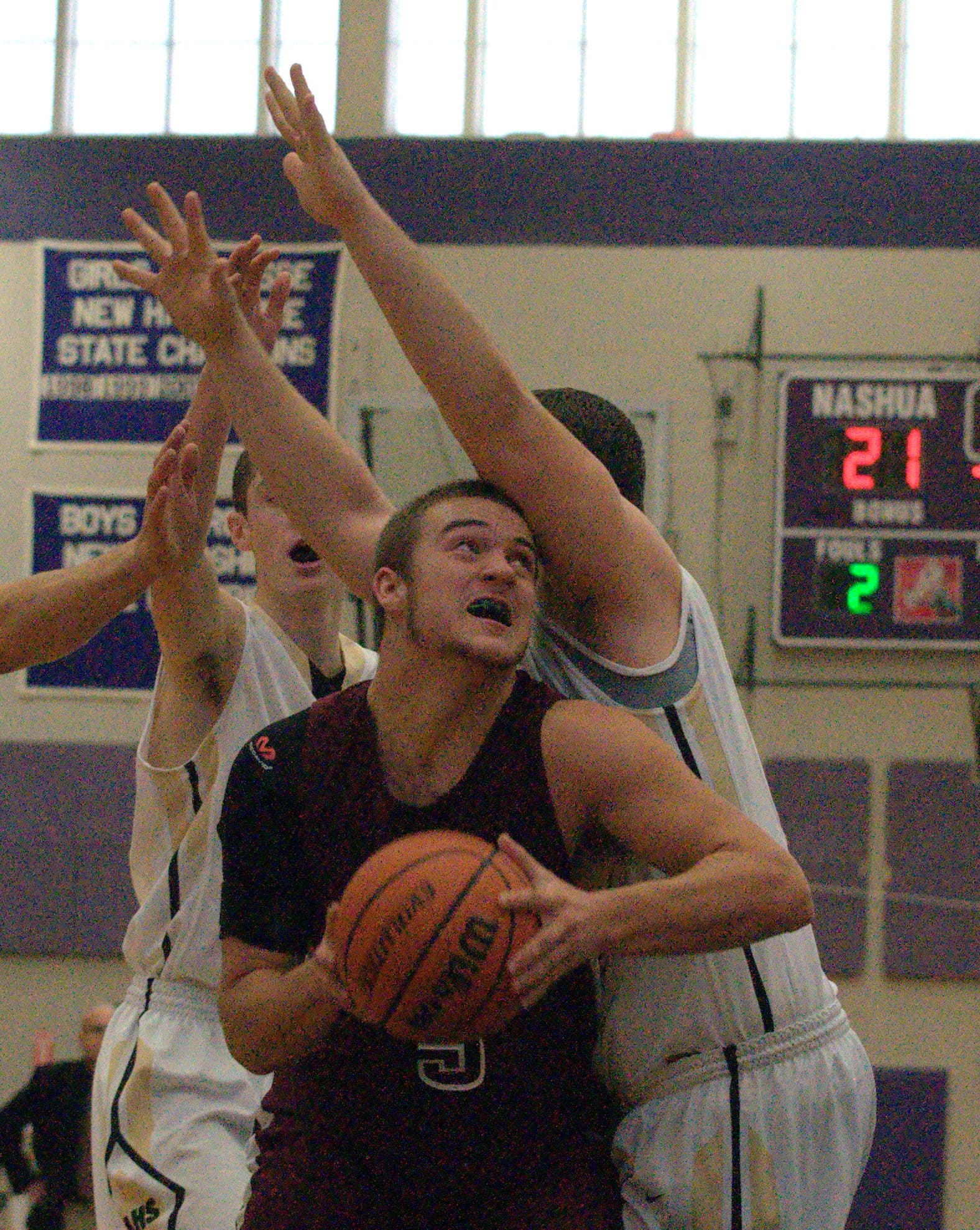 Goffstown's Tim Comeau tries to get to the basket at Alvirne's Alex Christie defends.