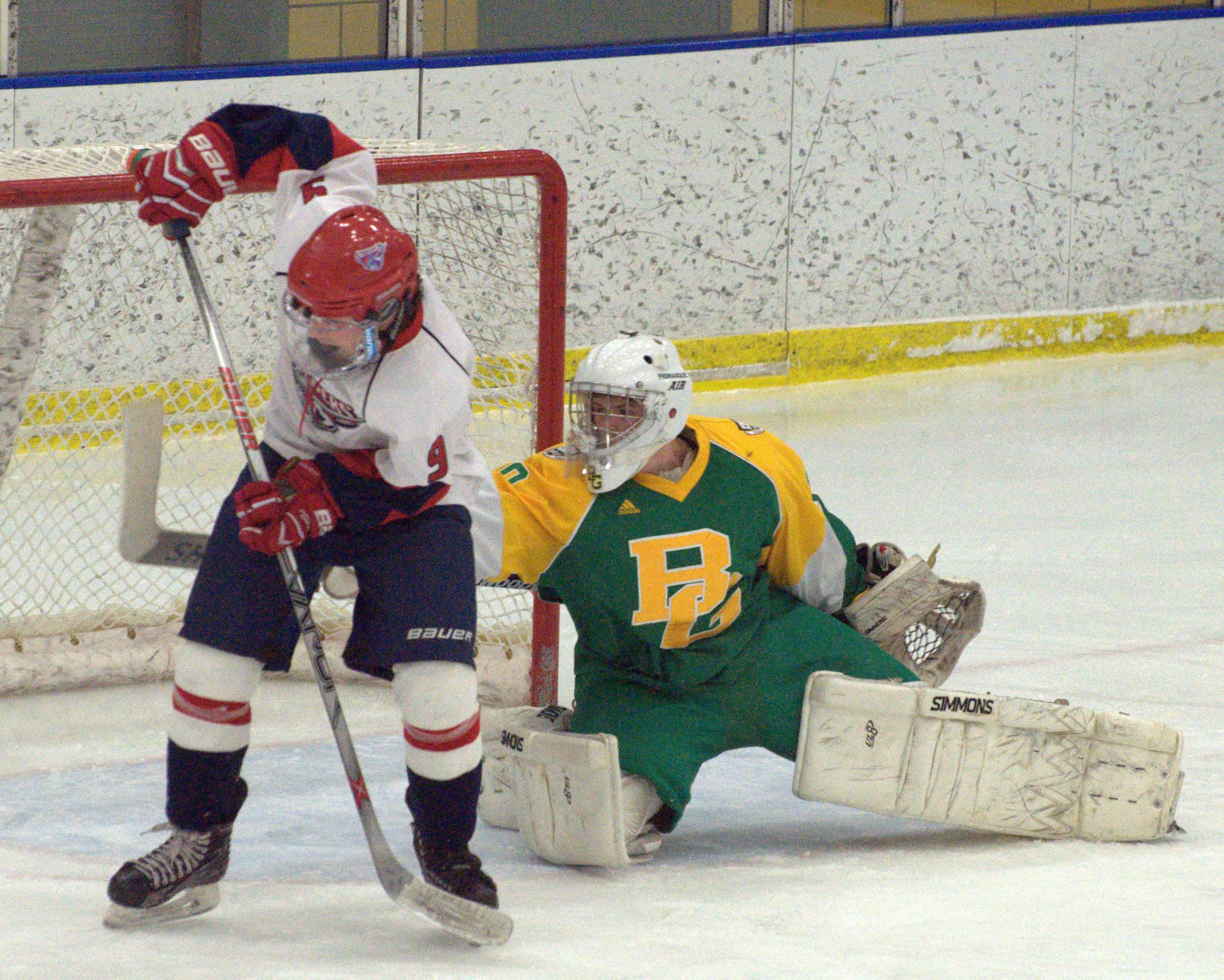 Bishop Guertin's Thomas Norton tries to make a save as Manchester Memorial's Ryan Sullivan stands in front of the net.