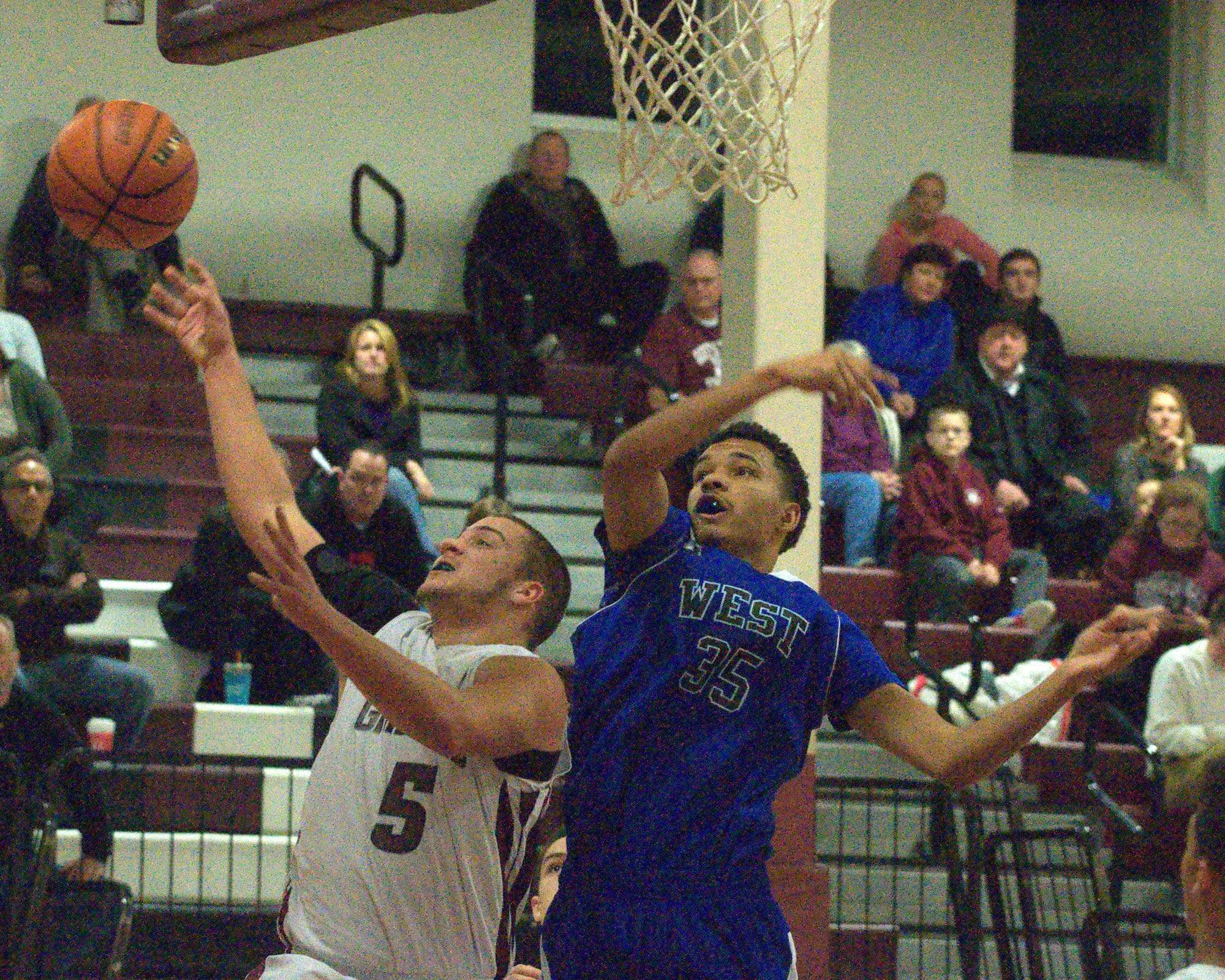 Goffstown's Tim Comeau tries to put up a shot as Manchester West's Keenan Caron defends.