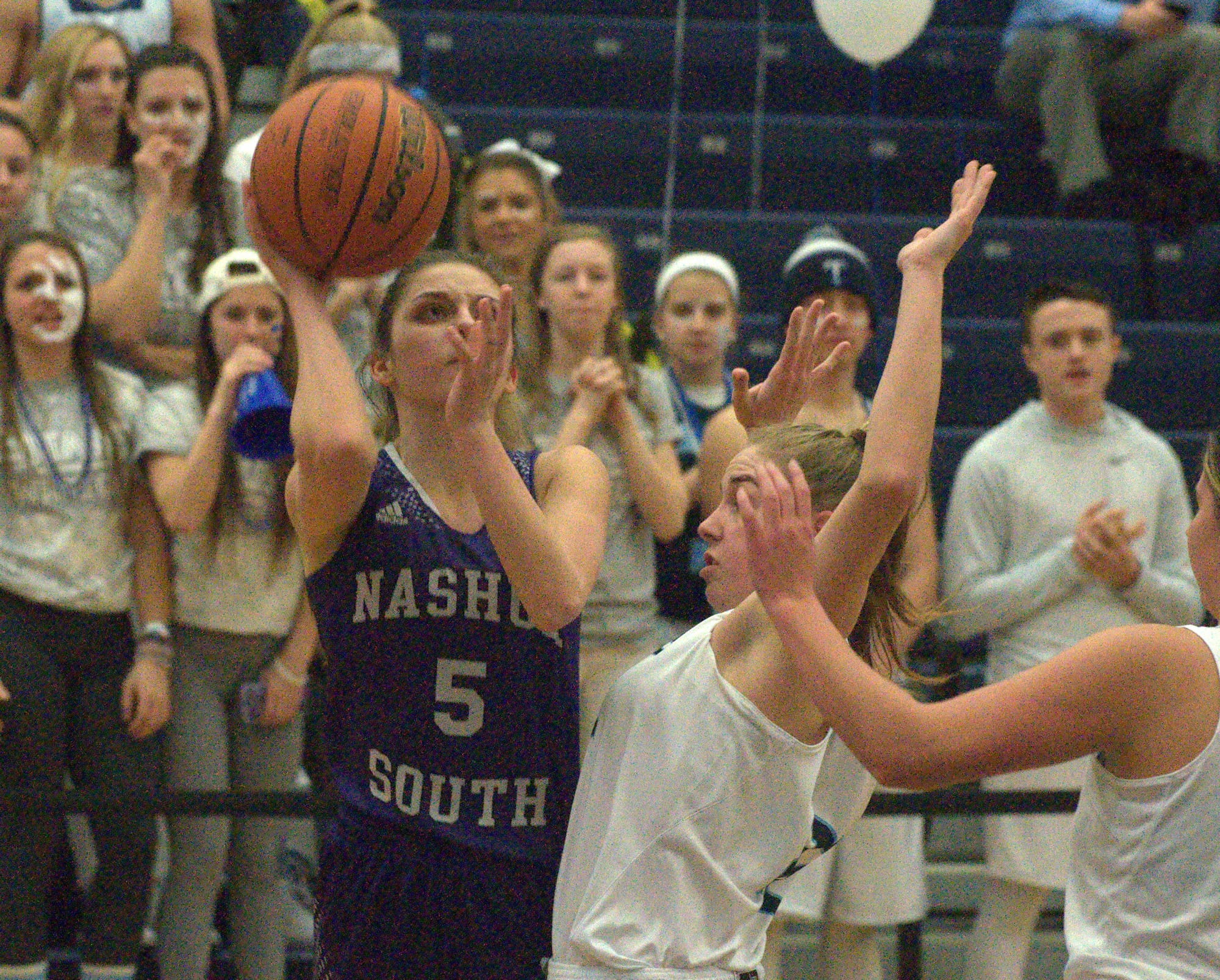Nashua South's Jocelyn Chaput takes a shot as Nashua North's Isabel Dunning defends.