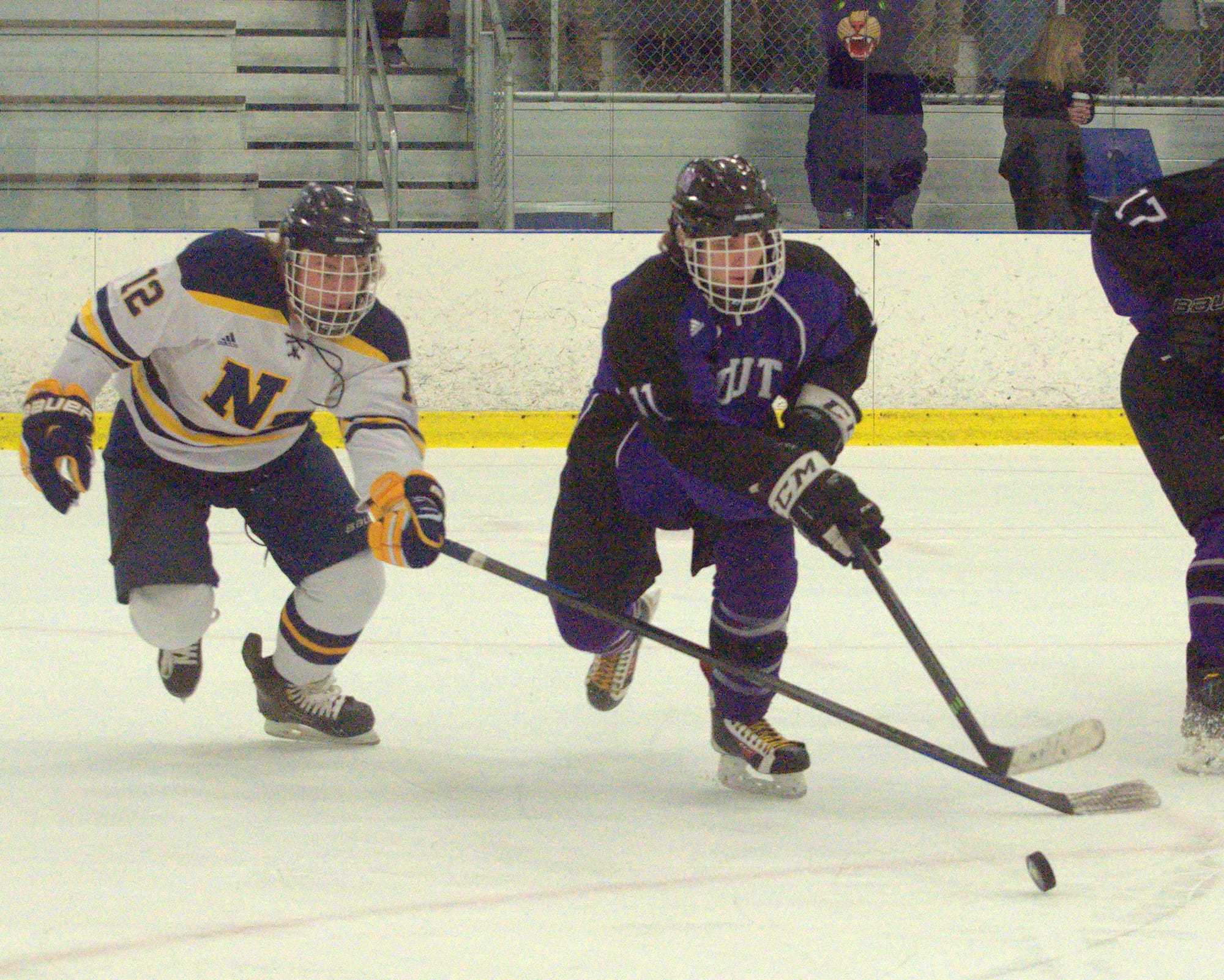 Nashua North-Souhegan's Dean Paquette tries to knock the puck away from Nashua South's Tyler Goy.