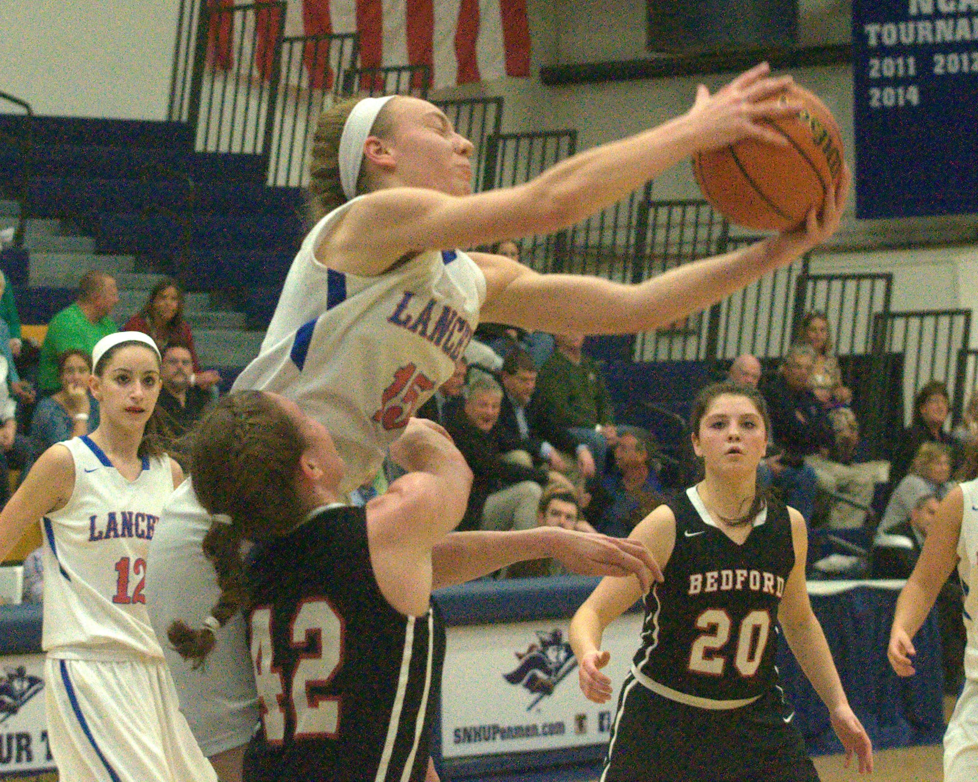Londonderry's Kate Balcom grabs a rebound over Bedford's Madeline Blake.