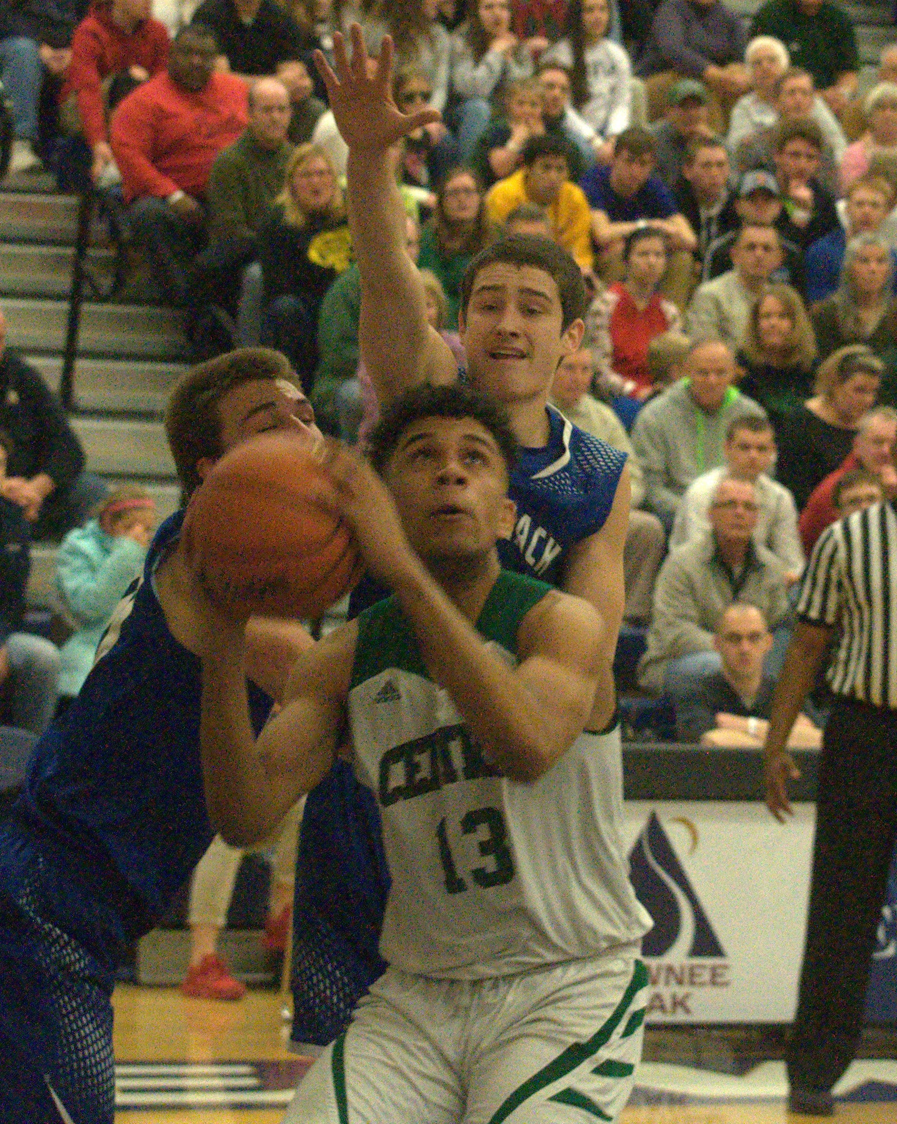 Manchester Central's Jaylen LeRoy goes to the basket as Merrimack's Andrew Wojciak defends.