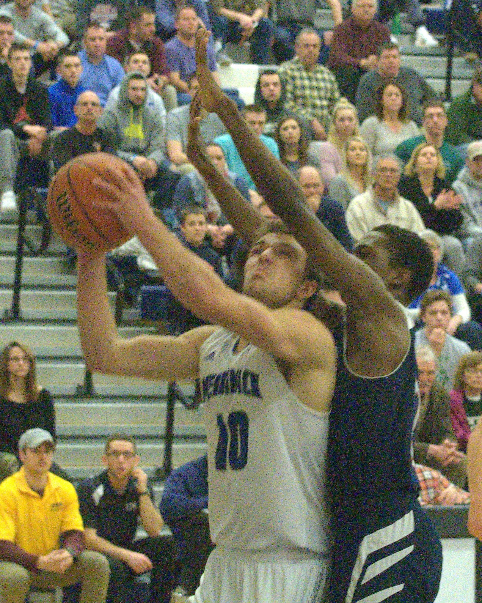 Merrimack's Dan McKillop tries to go up for a layup as Manchester Memorial's Malo Roumraj defends.
