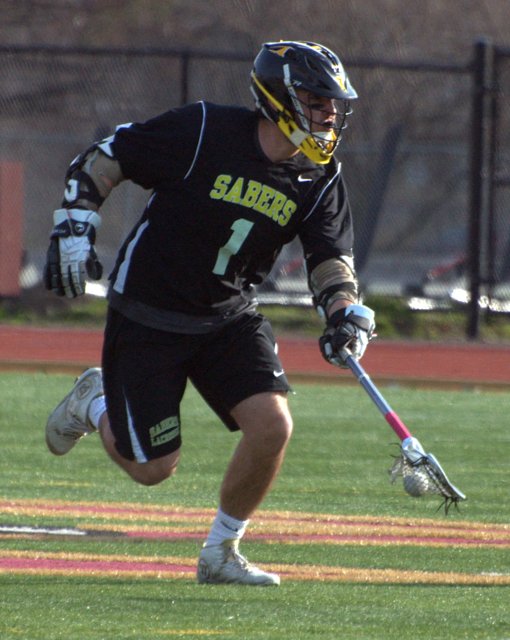 Souhegan's Tim Vinton picks up the ball after winning a faceoff.