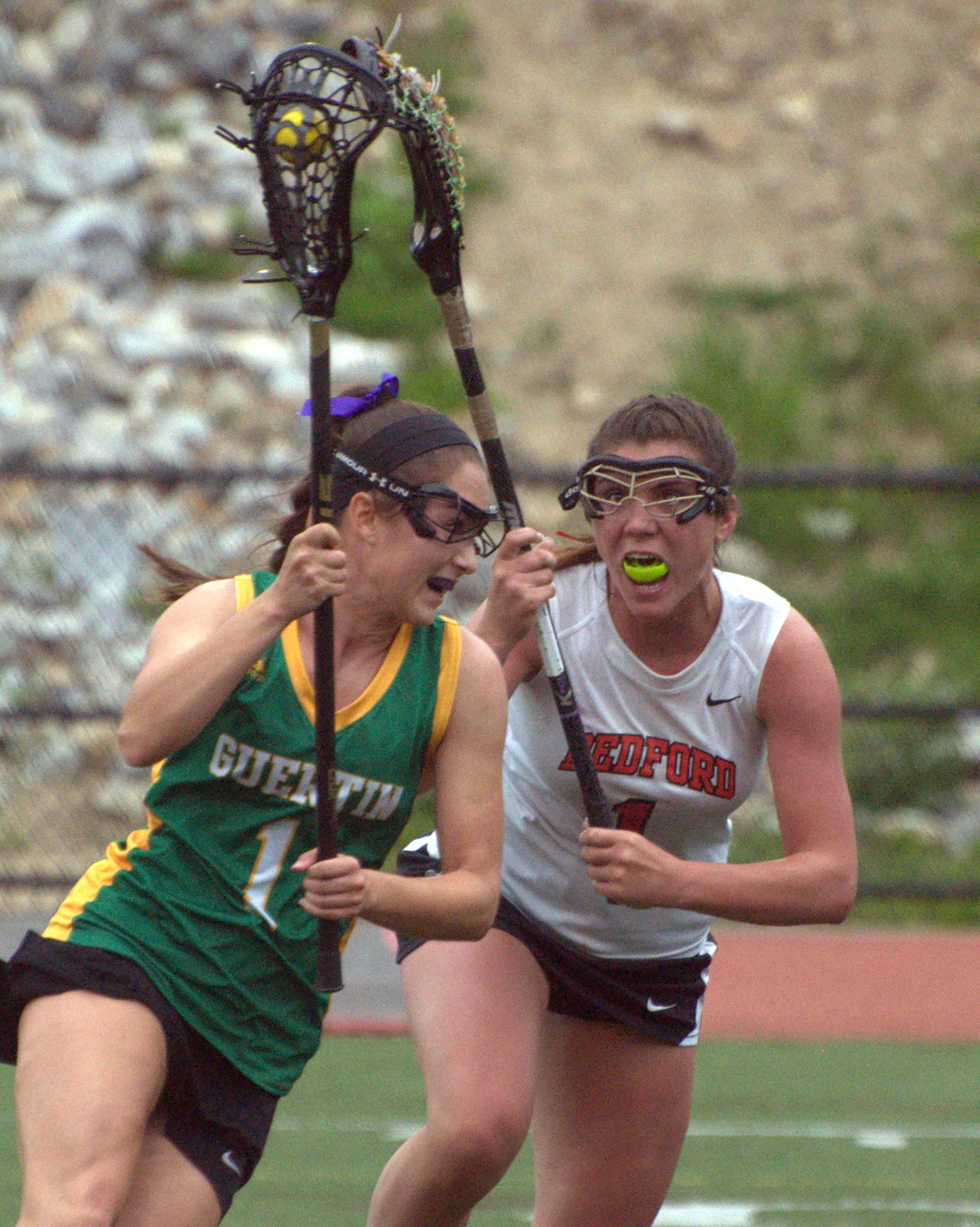 Bedford's Kennedy Boyle defends as Bishop Guertin's Olivia Koutsos runs with the ball.