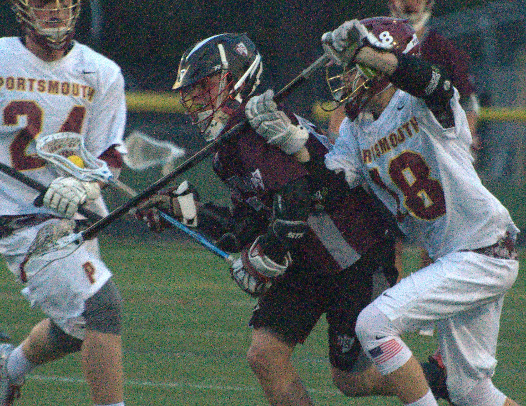 Portsmouth's Luke Squire tries to slow down Derryfield's Brian Schwab.