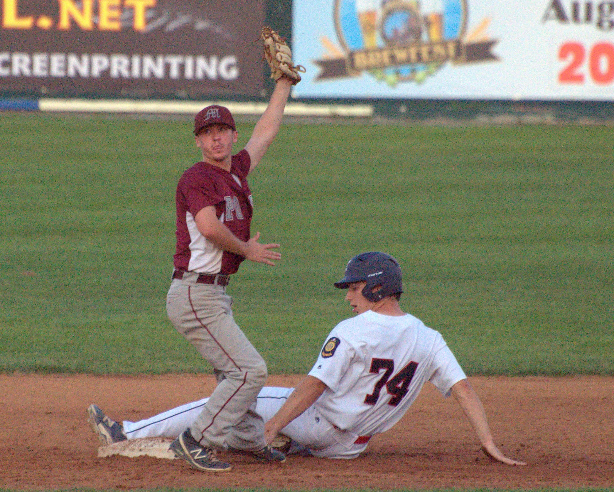 Merrimack's Brendan Carter holds up the ball after tagging Milford's Bryce Walker.
