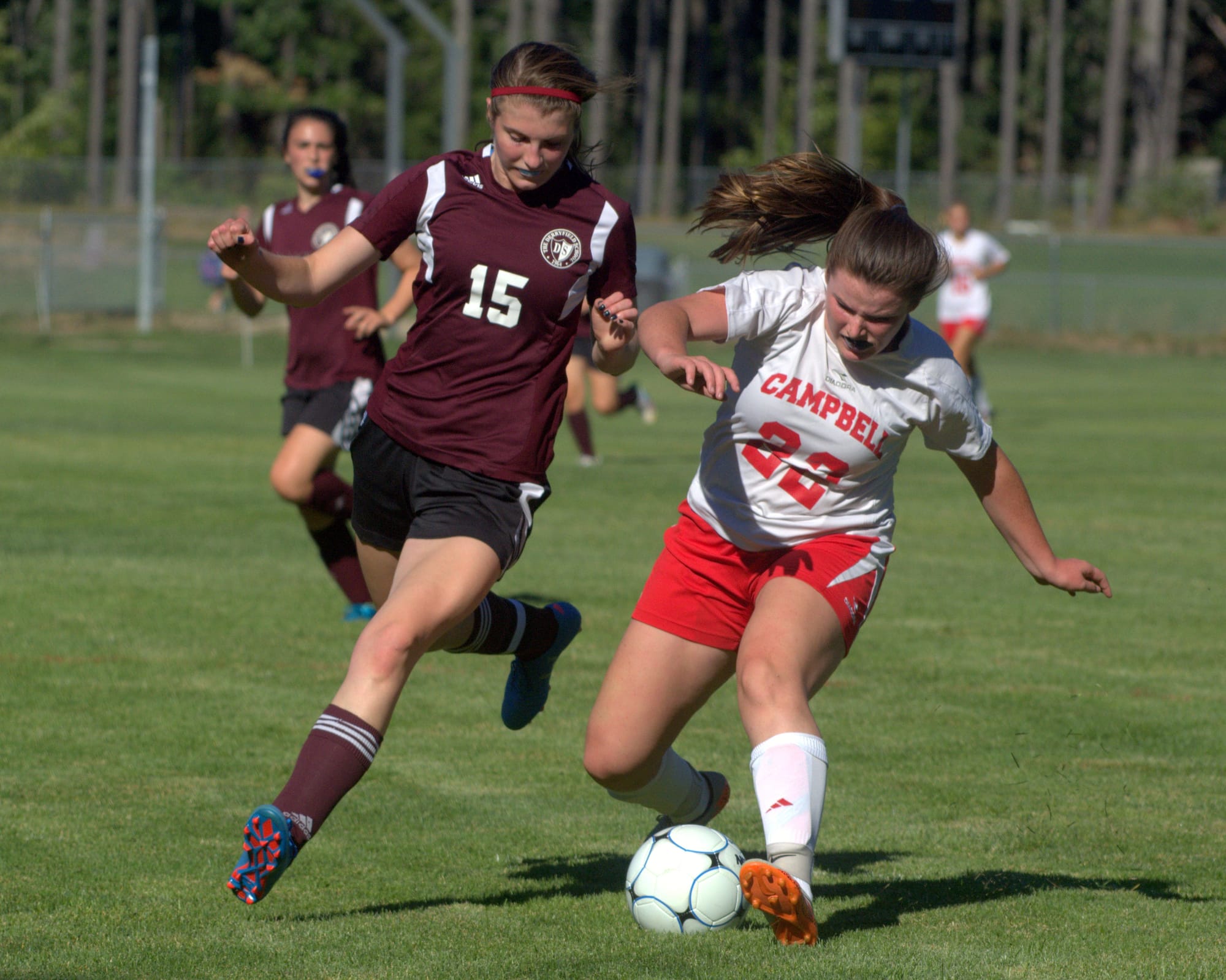 Derryfield's Erika Wentz tries to slow down Campbell's Erin Douglas.