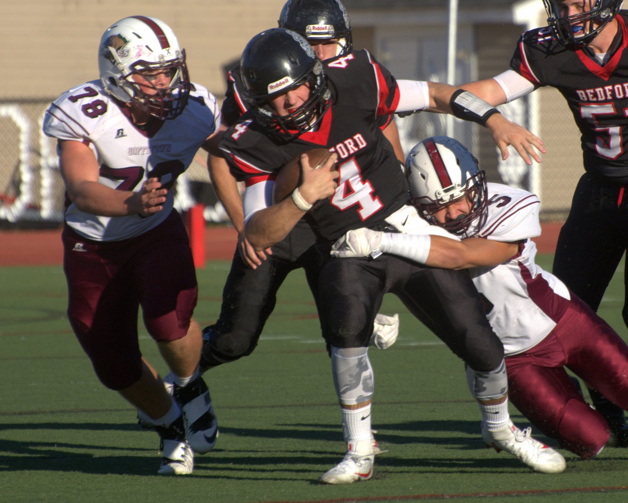 Goffstown's Joey Poisson tries to bring down Bedford's Connor Robert.