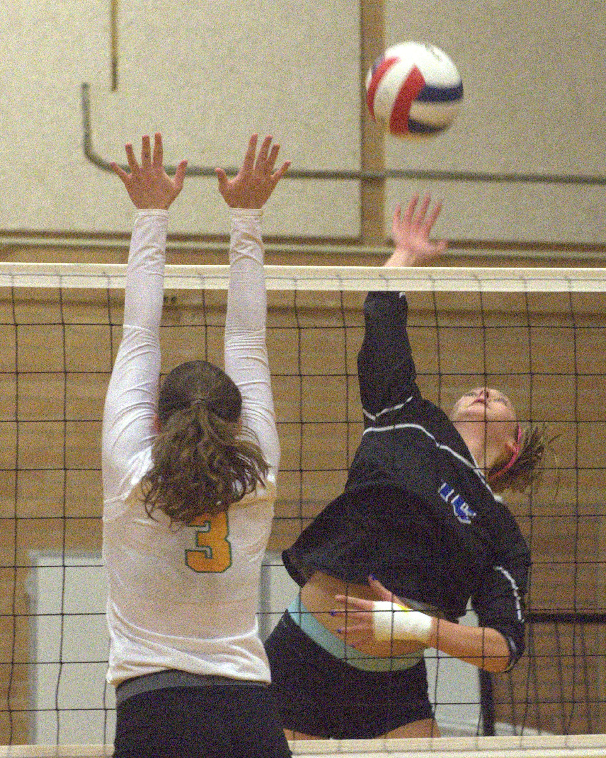 Hollis Brookline's Maddie Norris tries to hit the ball over Bishop Guertin's Jenna McCormack.