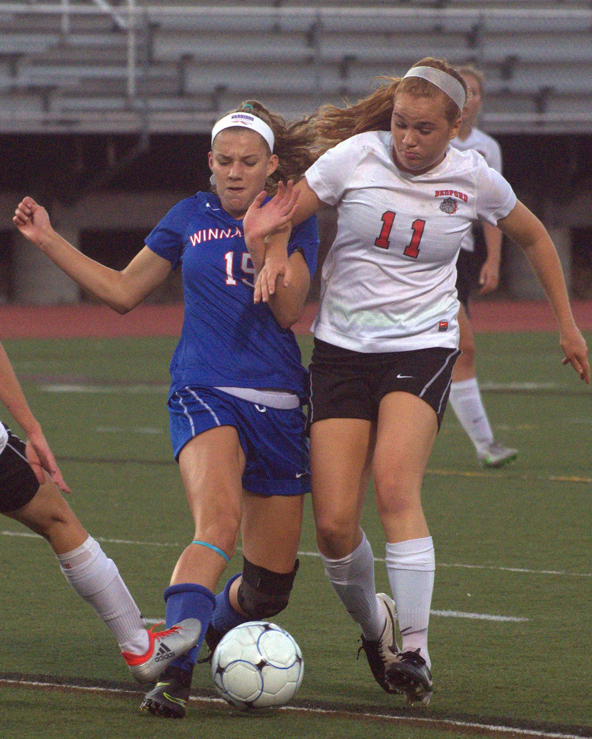 Winnacunnet's Tess Rodgers and Bedford's Natalie Kelley battle for the ball.