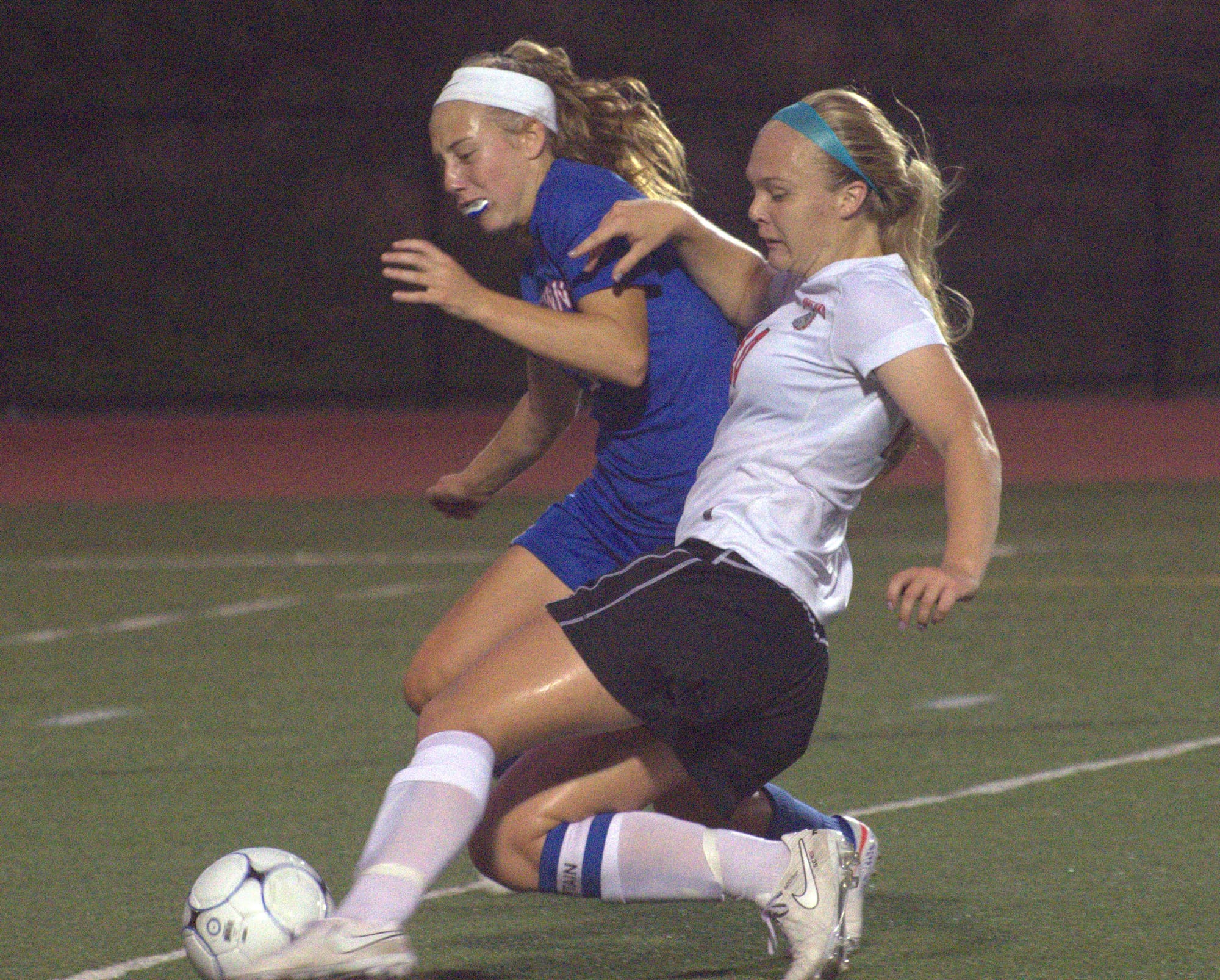 Winnacunnet's Alisyn McNamara tries to knock the ball away from Bedford's Saylor Clark.
