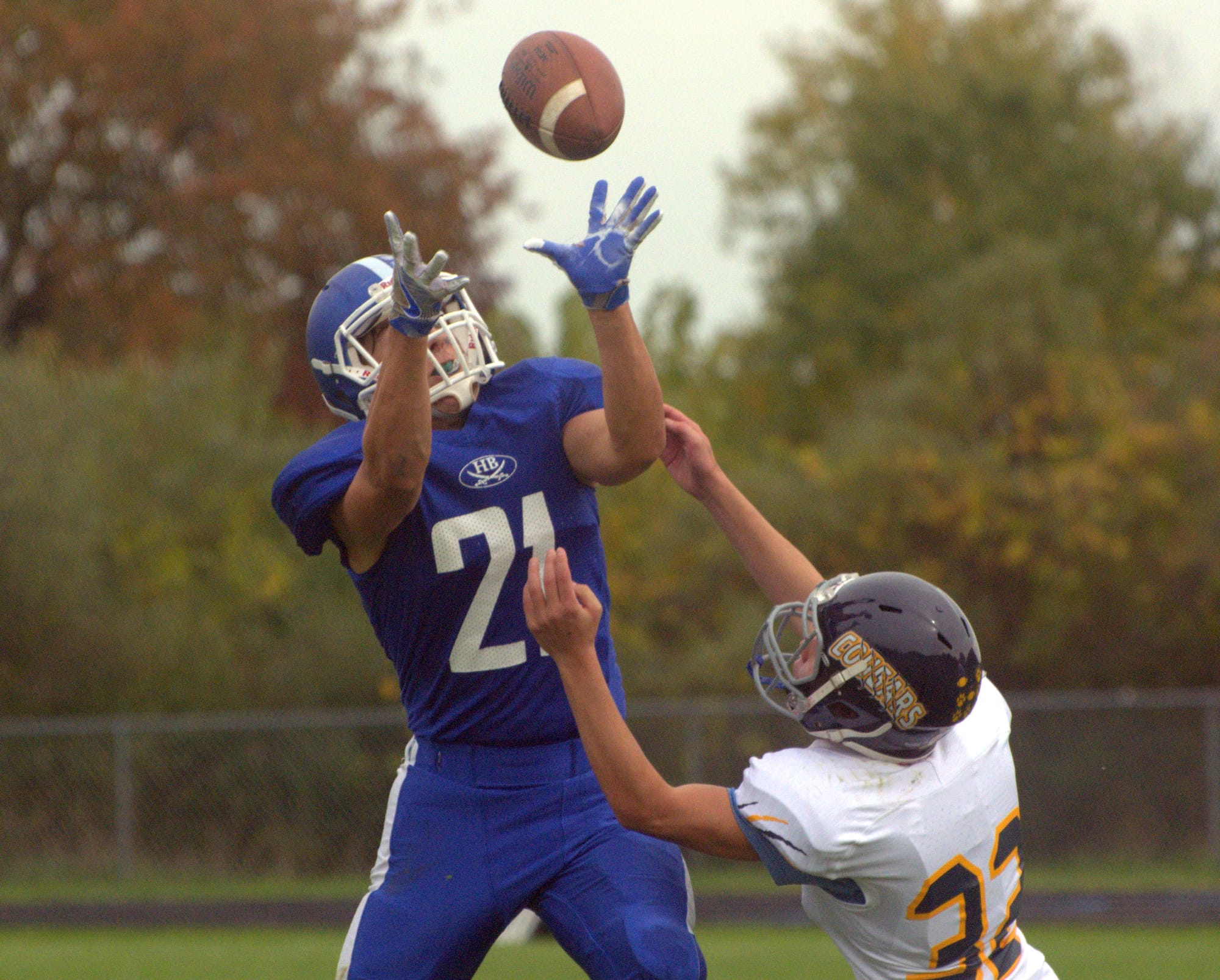 Hollis Brookline's Brian Delaney goes up to make a catch over ConVal's Hunter Gullage.