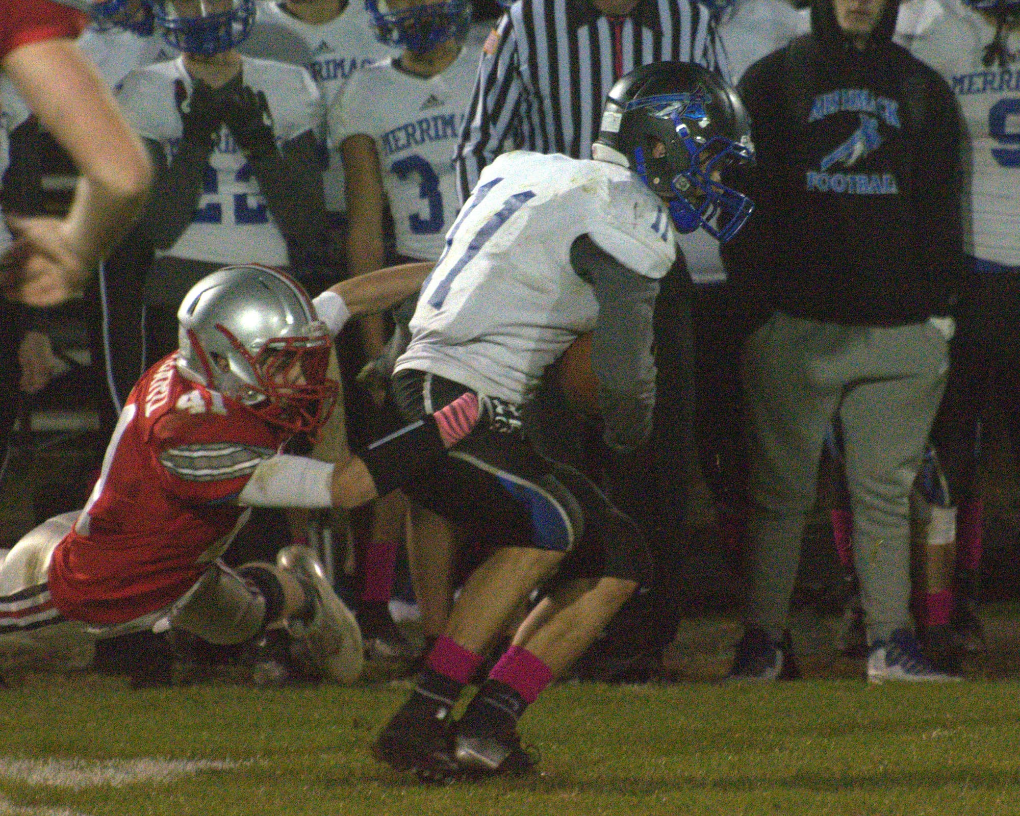 Merrimack's Justin Weiser tries to break a tackle by Pinkerton's Nicholas Lombard.