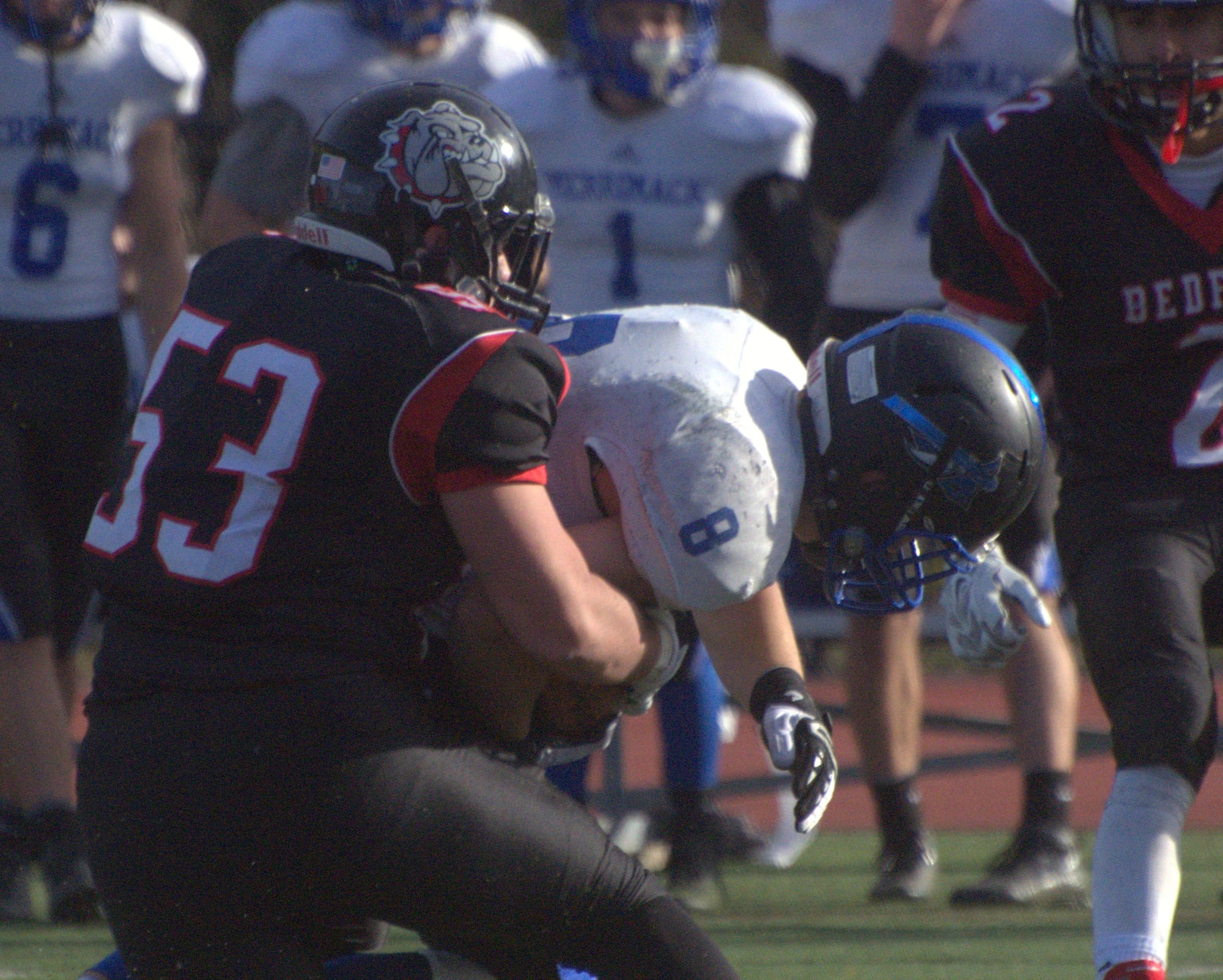 Bedford's Spencer Adams wraps up Merrimack's Joe Eichman.