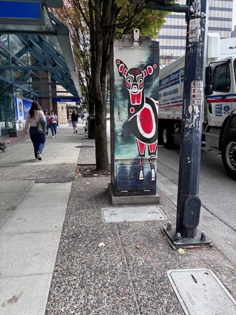 red, white, and black deer painted on a steel electrical box in the Pacific Northwest Indigenous style.
