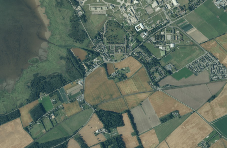Aerial view of Kinloss Abbey showing a large shield-shaped feature encircling the abbey site